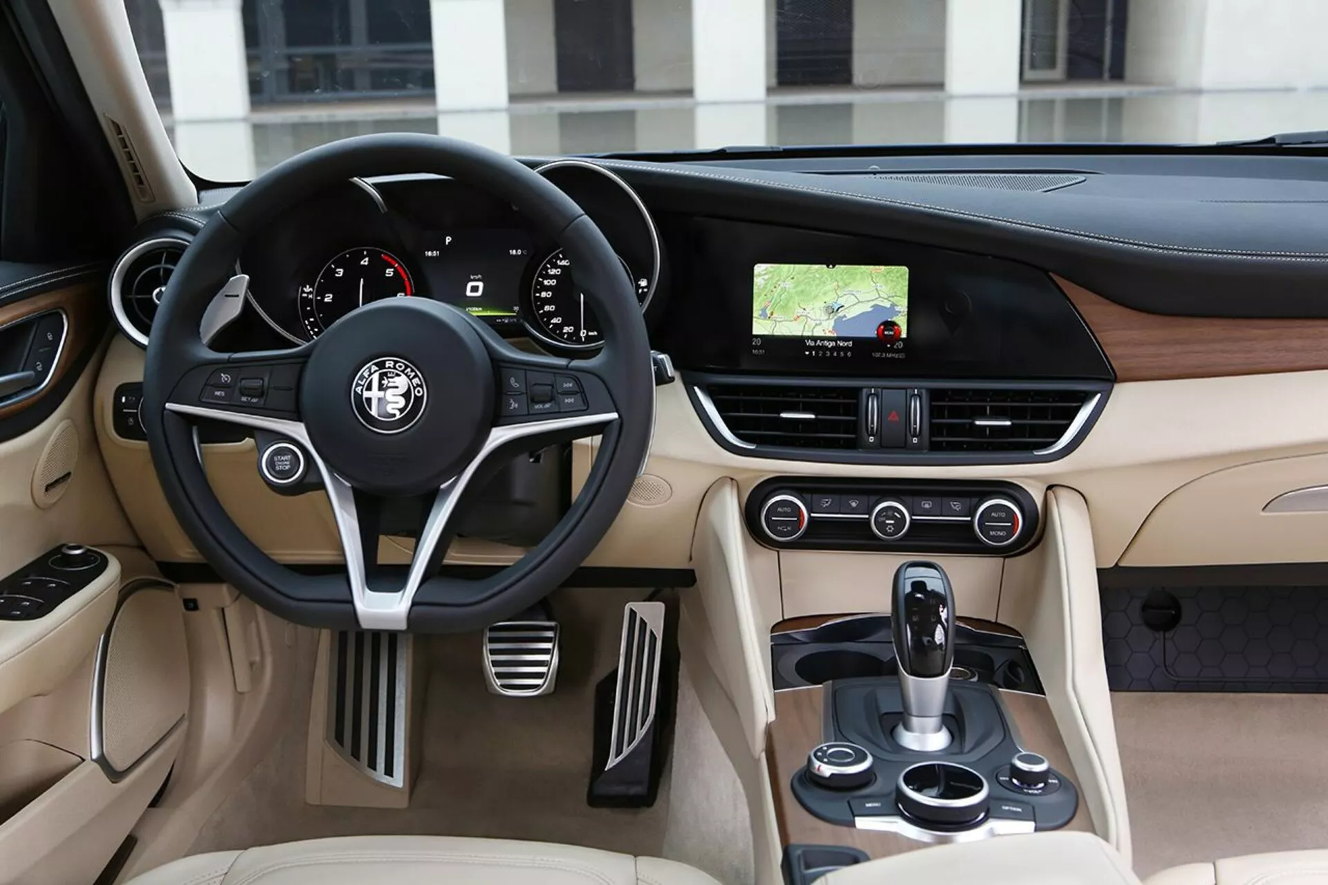 Interiér Alfa Romeo Giulia 2016 s pohľadom na stranu vodiča, kožený volant, palubná doska a stredová konzola