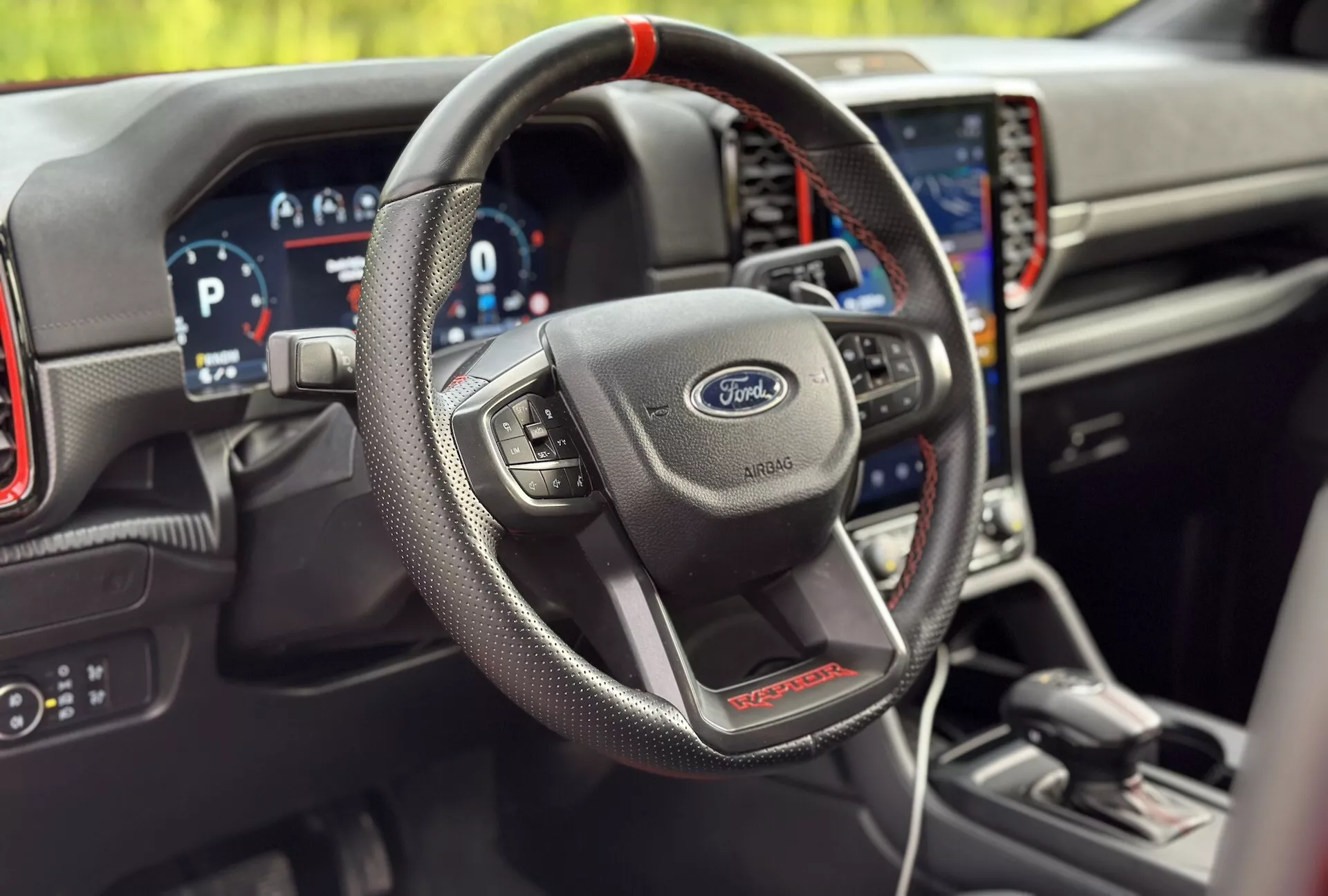 Interiér Ford Ranger 2022, zdôrazňujúci volant obalený kožou s multifunkčnými ovládacími prvkami, digitálny prístrojový panel a integrovaný navigačný systém vo športovej variante ST