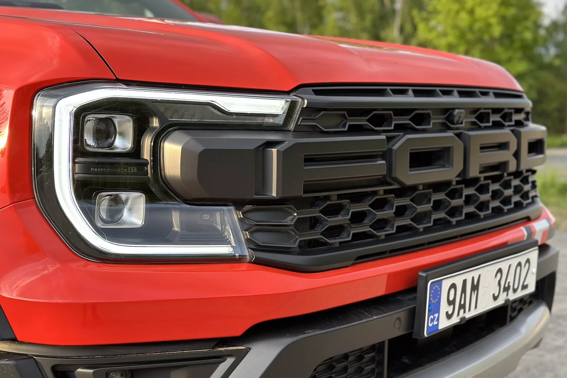 Detailný pohľad na prednú ľavú stranu Fordu Ranger 2022, zdôrazňuje dizajn LED svetlometov a včelou mriežku s nápisom 'FORD'