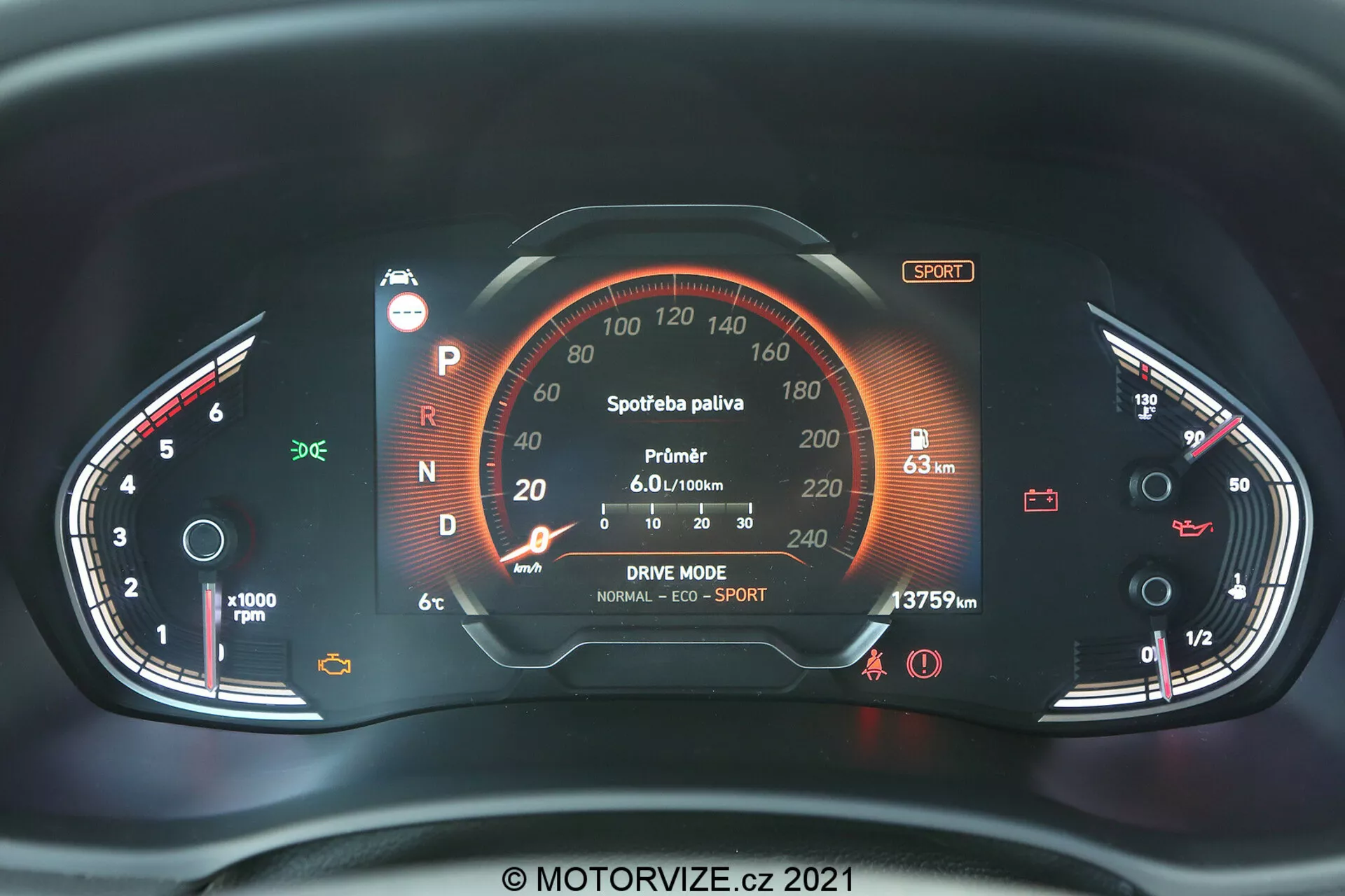 Detailný pohľad na digitálnu prístrojovú dosku Hyundai i30 2020 (i30-kombi) zobrazujúci analógový otáčkomer vľavo a rýchlomer vpravo. Stredný digitálny displej ukazuje rôzne indikátory vozidla vrátane polohy prevodovky 'P', výkonového merača označeného 'Sportbaterie paliva', priemernú spotrebu 'Průměr 6.0 l/100km', možnosti jazdného režimu 'NORMAL | ECO | SPORT', počítadla kilometrov '137579 km' a indikátory paliva a teploty. Ďalšie viditeľné ikony zahŕňajú varovanie o bezpečnostnom páse, upozornenie na otvorené dvere a kontrolku stavu pohonného systému alebo batérie. Dátum autorských práv '2021' a 'MOTORVIZE.cz'.
