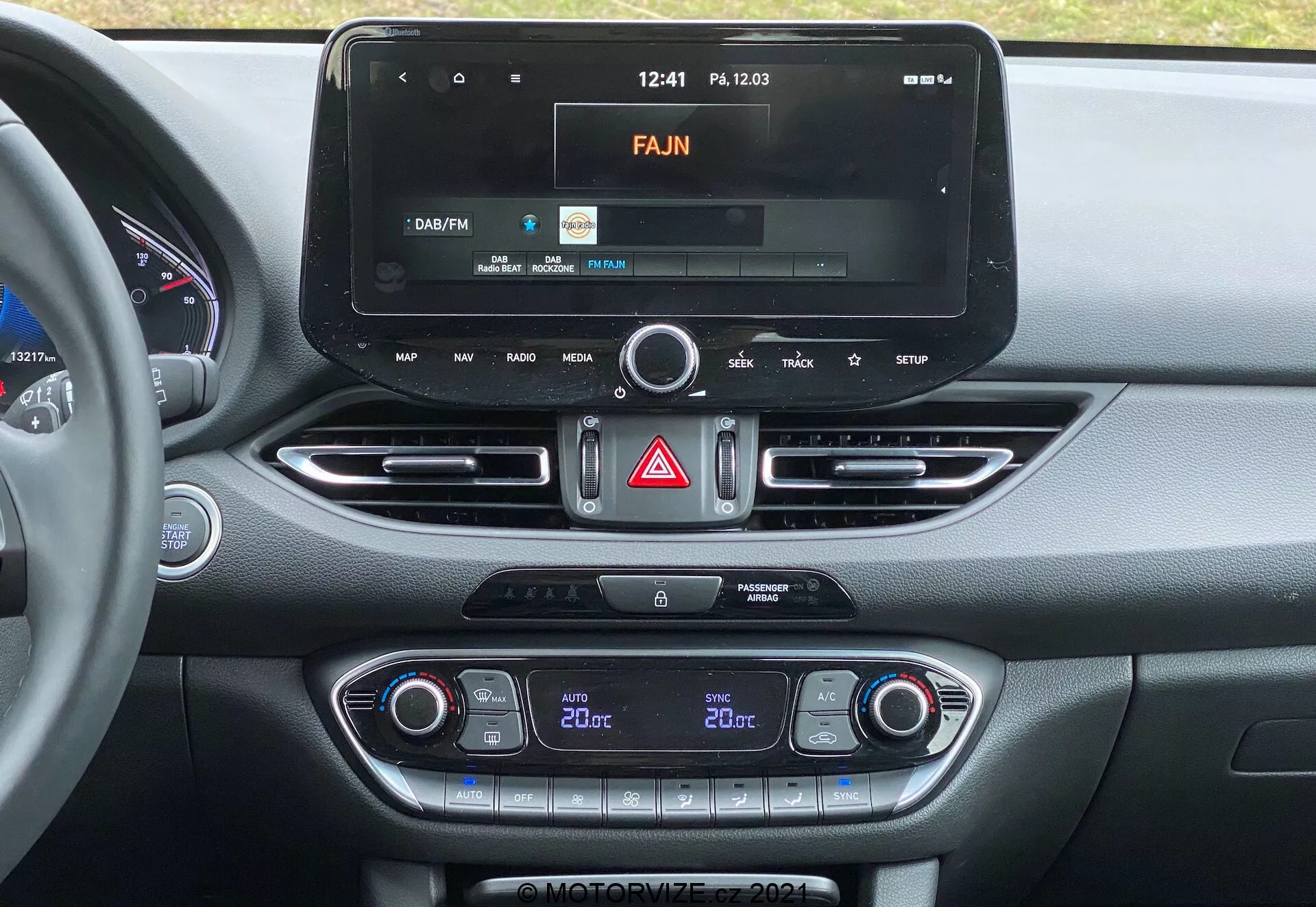 Stredová konzola Hyundai i30 2020 s moderným dotykovým infotainmentovým systémom, rádio rozhraním, dvojzónovou klimatizáciou a vetracími otvormi s kovovým povrchom.
