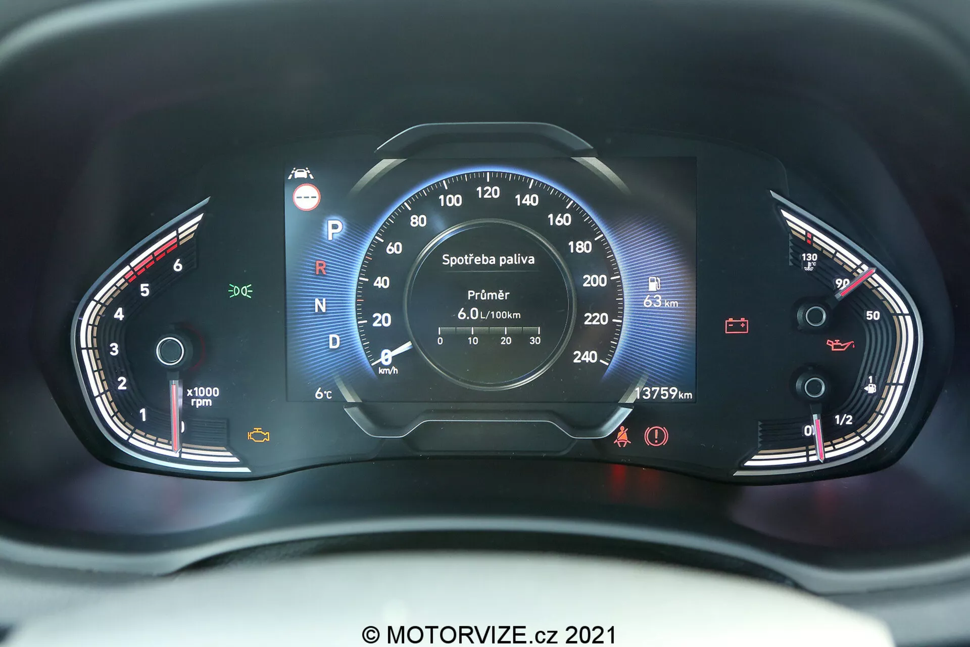 Detailný pohľad na prístrojový panel Hyundai i30 2020 z pohľadu sedadla vodiča. Obrázok zachytáva centrálne uhlovanie a odhaľuje analogové aj digitálne prvky. Na ľavej strane je otáčkomer dosahujúci až 8 000 RPM s malým teplomerom. Na pravej strane je rýchlomer až do 260 km/h a palivomer. Stredový digitálny displej zobrazuje informácie ako výber prevodového stupňa (aktuálny stupeň je Parkovanie), čítanie počítadla kilometrov (37579 km), digitálny rýchlomer (---- km/h) a detaily počítača na cestajne o spotrebe paliva a zostávajúcom dojazde. Prístrojový panel je osvetlený červenými a bielymi svetlami pre lepšiu viditeľnosť a šetrenie nočného videnia. Na obrázku je vodoznak 'MOTORVIZE.cz 2021'.