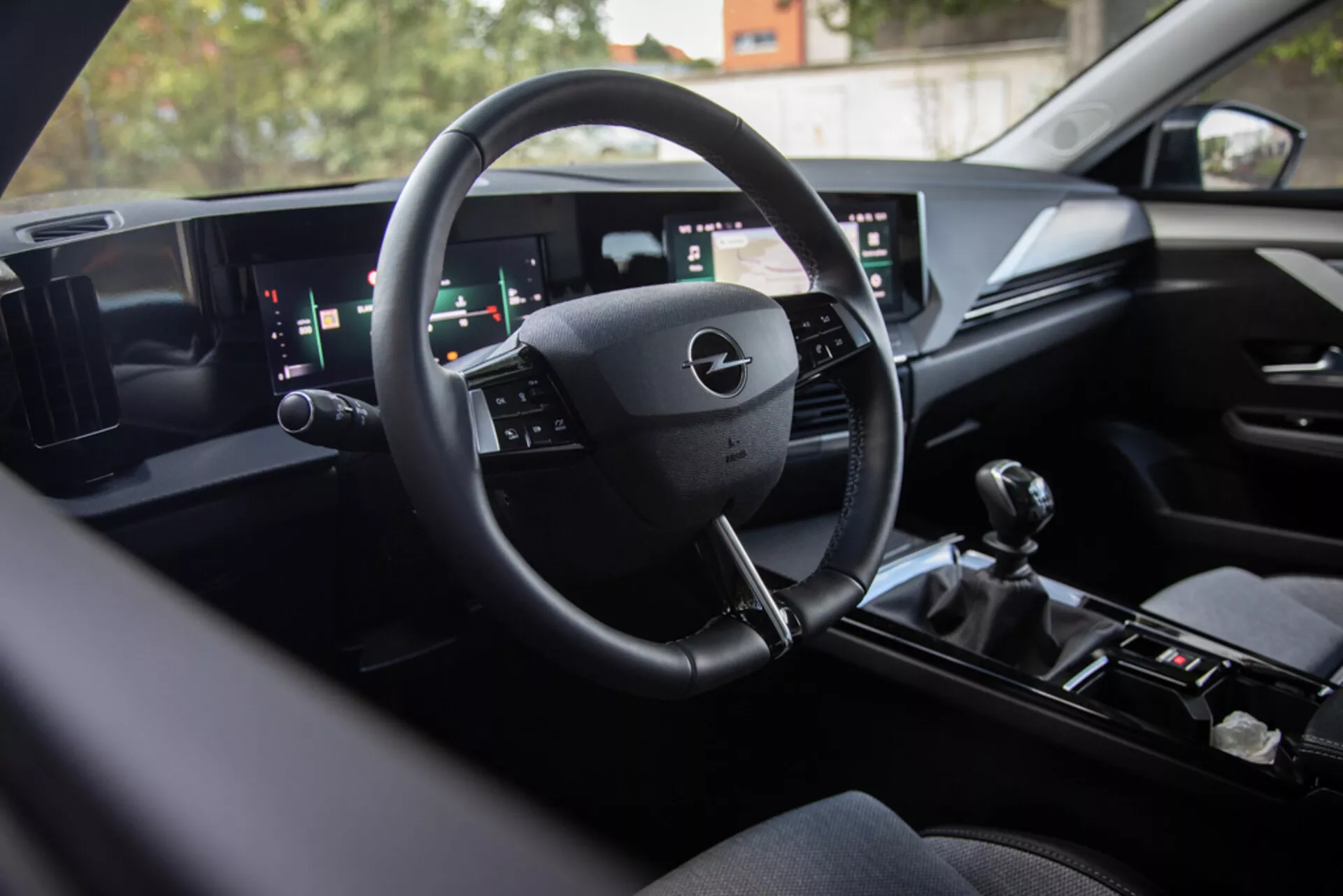 Interiér Opelu Astra 2022 predvádzajúci modernú technológiu digitálneho palubného dosky, multifunkčný volant, široký duálny informačný systém a manuálnu radiacu páku pre športový výkon, pohľad zo zadného sedadla smerom k vodičovi s prémiovými povrchovými úpravami