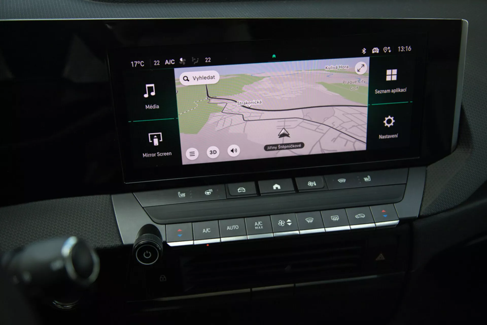 Detailný pohľad na systém infotainment a ovládacie prvky klimatizácie v stredovej konzole Opel Astra 2022, zobrazujúci GPS navigáciu na displeji, Bluetooth konektivitu a nastavenie teploty