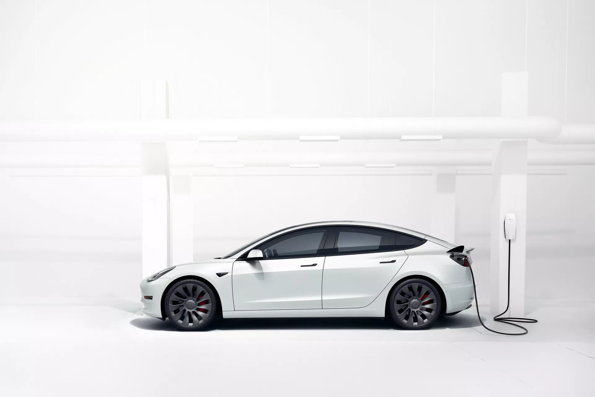 Tesla Model 3 2019 Prvá generácia v elegantnej striebornej farbe s moderným aerodynamickým dizajnom, sklenenou strechou, minimalistickým interiérom, veľkým centrálnym dotykovým displejom a inovatívnymi schopnosťami autopilota.