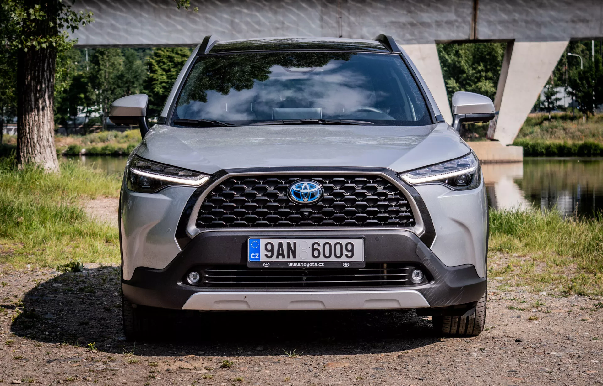 Predný pohľad na Toyota Corolla Cross 2022 ukazujúci mriežku, svetlomety a nárazník, zdôrazňujúci pokročilý dizajn a technológiu