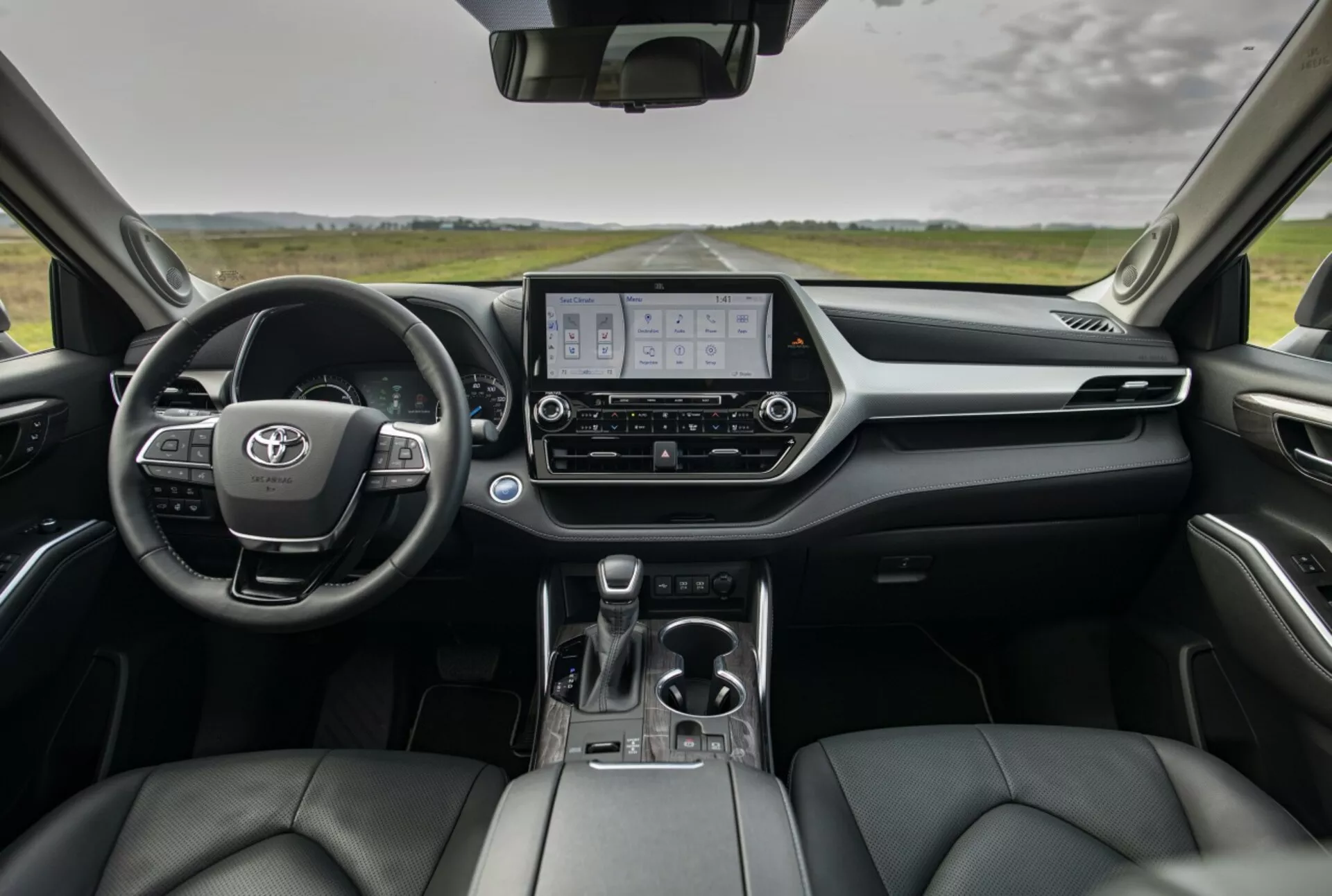 Prehľad interiéru Toyoty Highlander 2021 zobrazujúci palubnú dosku, digitálny prístrojový panel, displej informačno-zábavného systému a sedadlá s koženým poťahom z pohľadu zadných sedadiel