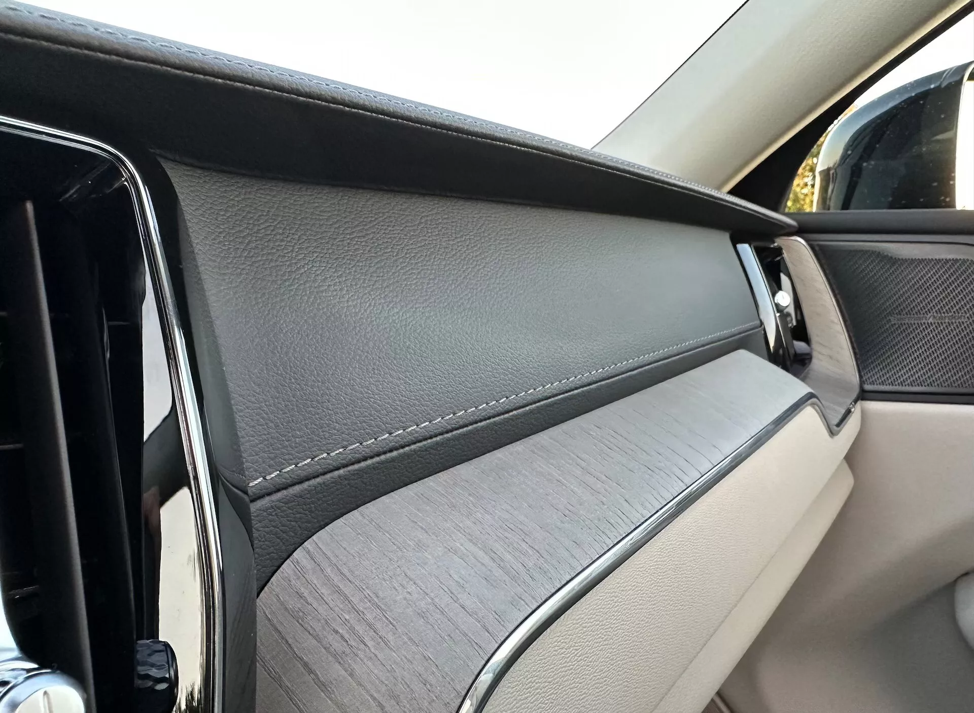 Detailný pohľad na vnútorný dverový panel Volvo XC60 2021 Recharge Plug-In Hybrid z pohľadu cestujúceho, zdôrazňujúci luxusné materiály a dizajnové prvky.