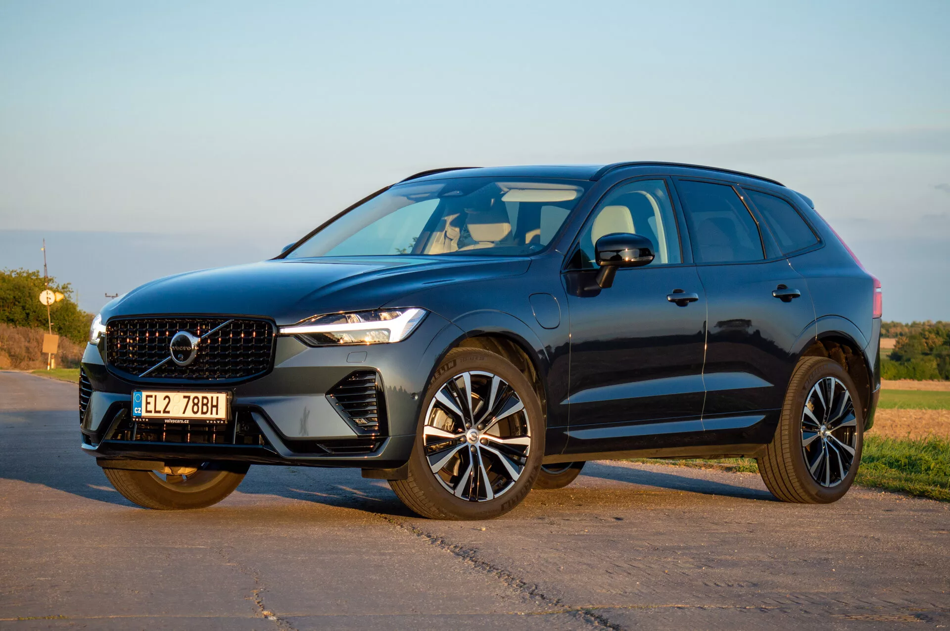 SUV Volvo XC60 Recharge Plug-In Hybrid 2021 v trojštvrťovej prednej perspektíve predvádzajúcej LED svetlomety, elegantnú mriežku a moderné zliatinové kolesá pod prírodným denným svetlom