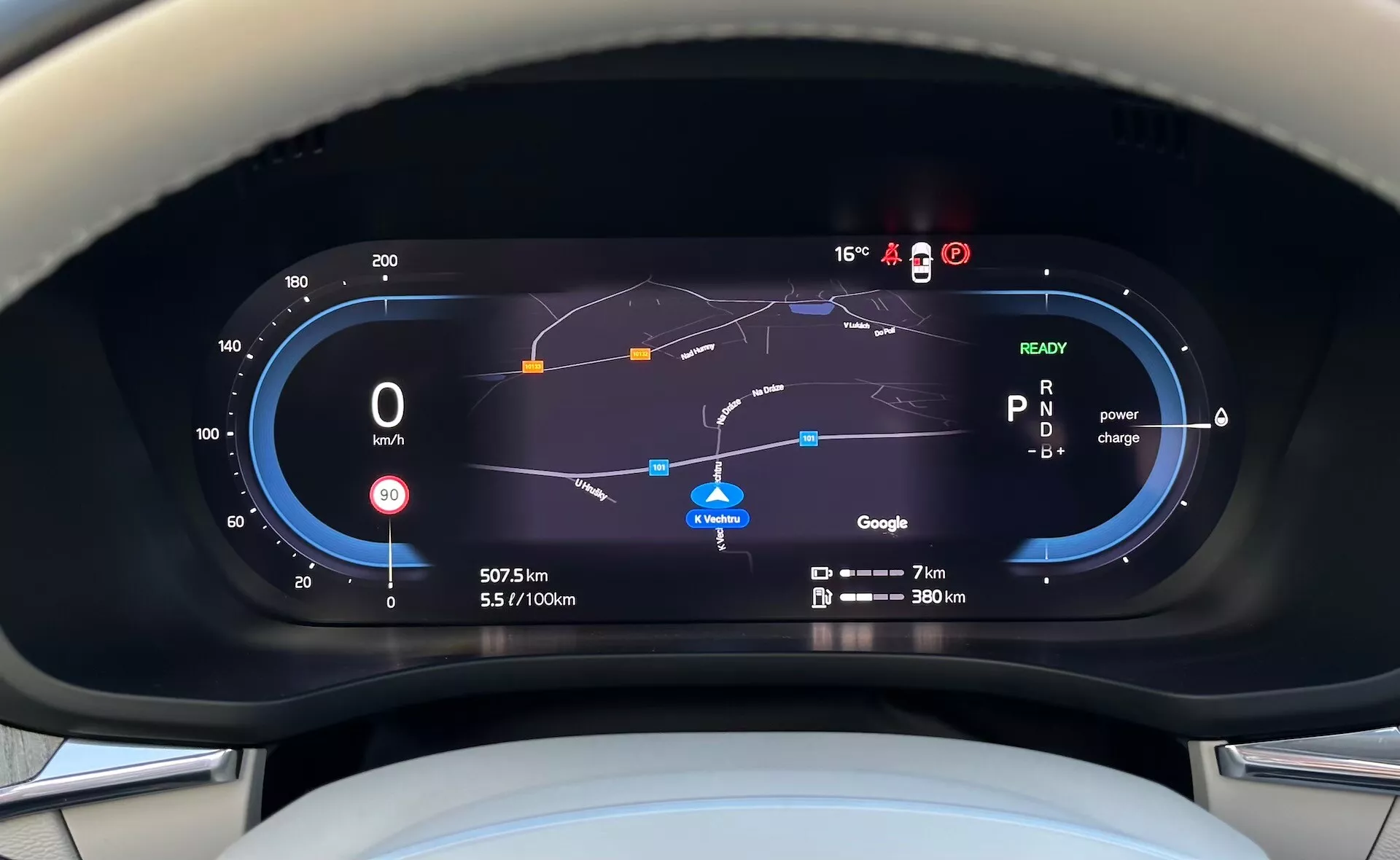 Digitálny prístrojový panel plug-in hybridu Volvo XC60 Recharge 2021 z pohľadu vodiča, zahŕňa tachometer, ukazovateľ účinnosti paliva, využitie výkonu, navigačnú mapu a rôzne ukazovatele jazdy