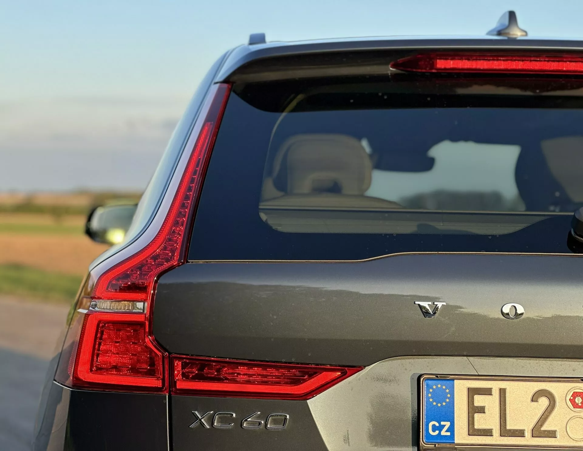 Volvo XC60 Recharge plug-in hybrid 2021 predvádzajúci svoje elegantne navrhnuté LED zadné svetlo, označenie AWD a charakteristické vonky napriek národniemu dni