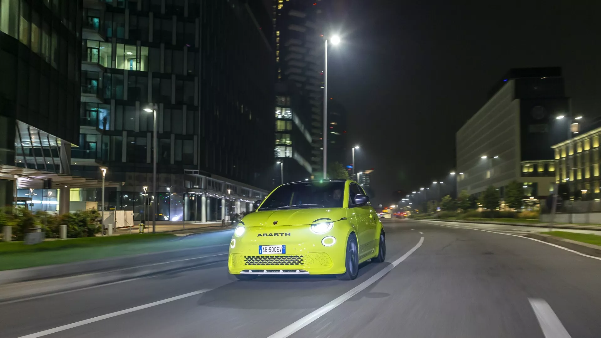Fotografia modelov Abarth 500, 595 a 695 z roku 2023 (2. generácia) z pravého predného uhla, zobrazujúca typickú prednú mriežku, LED svetlomety a športové dizajnové prvky. Auto je stacionárne na mestskej ulici, zachytávajúce technologické prvky a štýlový, kompaktný tvar, ktorý stelesňuje značku Abarth.