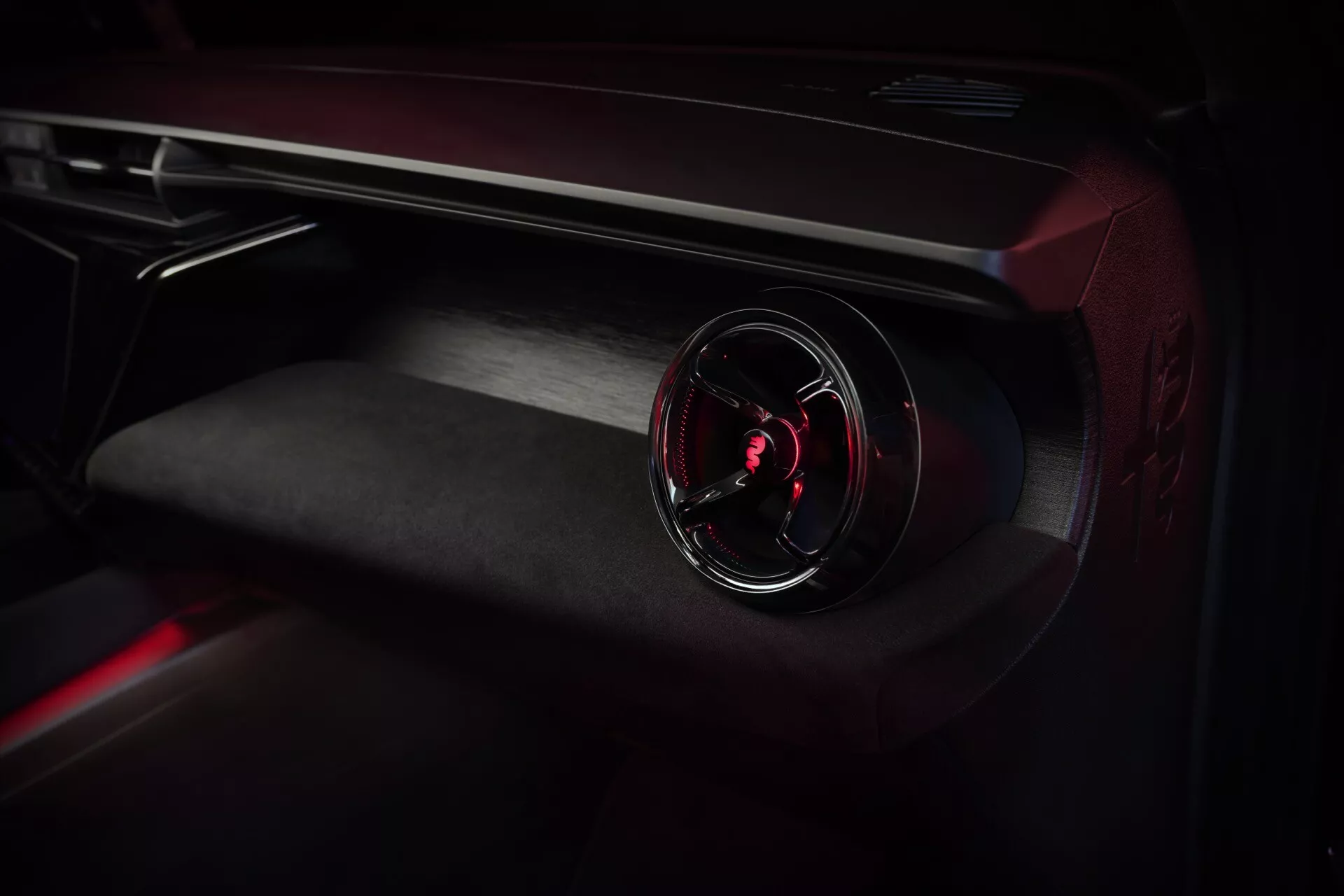 Detailný pohľad na interiér Alfa-Romeo Junior 2024 zameraný na palubnú dosku na strane spolujazdca s osvetlenou ventilačnou mriežkou a prémiovými materiálmi