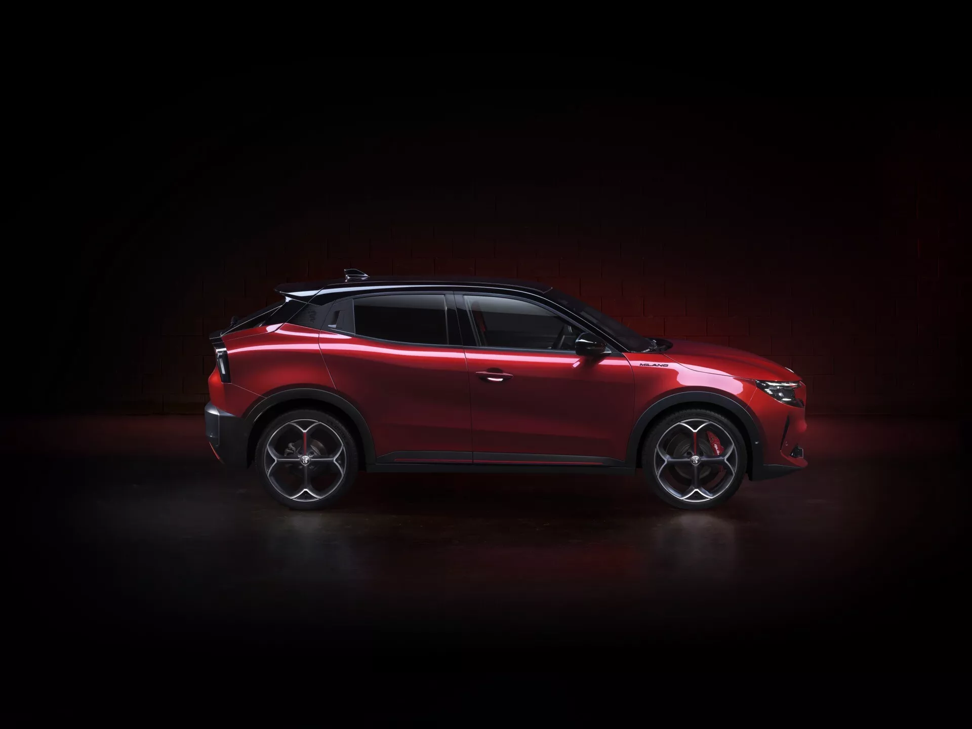 Alfa Romeo Junior (966) pre rok 2024 prezentovaný v dynamickom bočnom profile, zdôrazňujúci jeho športové zliatinové kolesá, LED svetlomety a štýlové dizajnové prvky pod dramatickým osvetlením