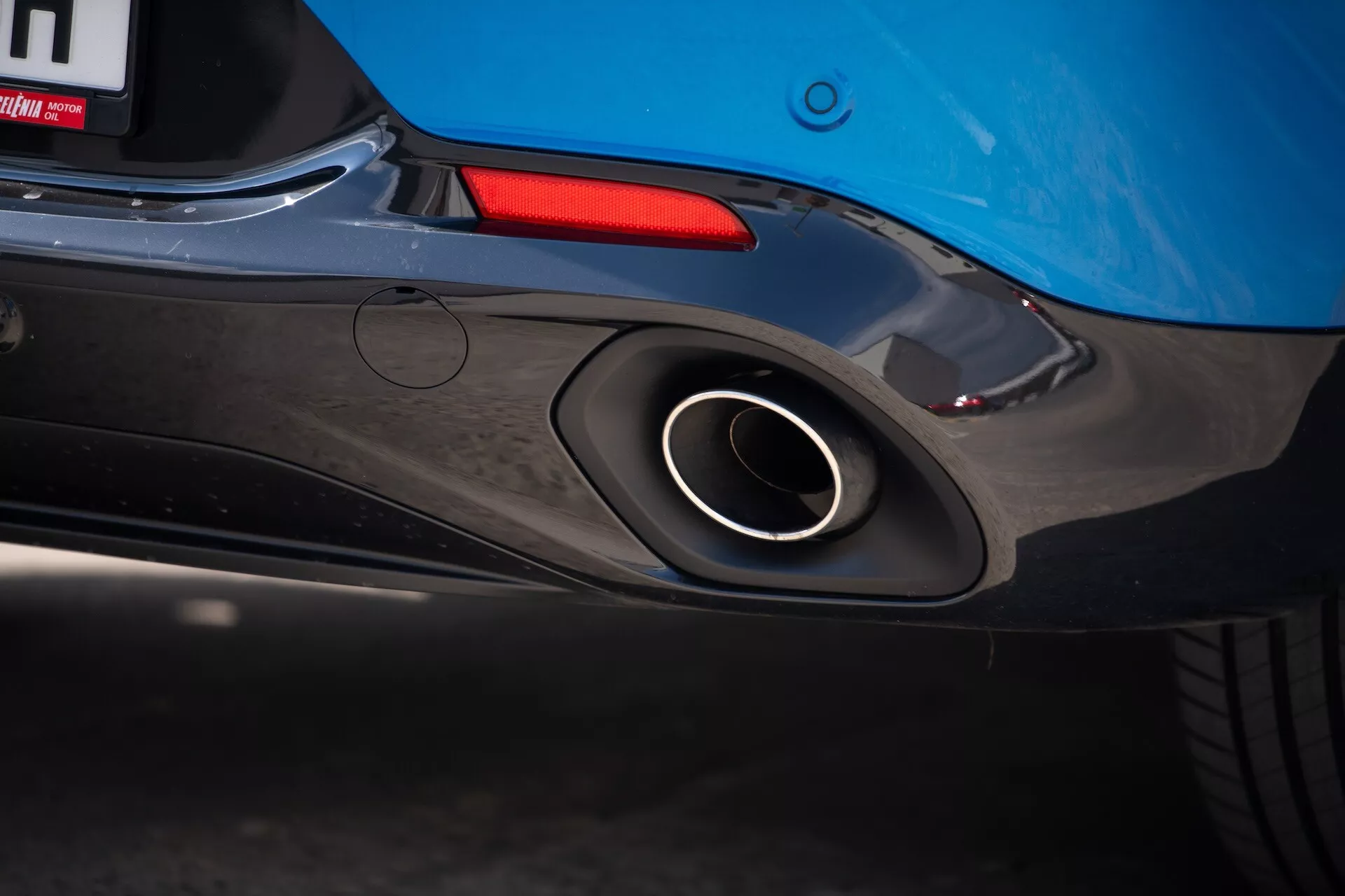 Detailný pohľad na zadnú časť Alfa Romeo Tonale 2022 s dôrazom na športový výfuk, aerodynamický dizajn zadného nárazníka a modrú farbu karosérie s nádychom zadného svetla