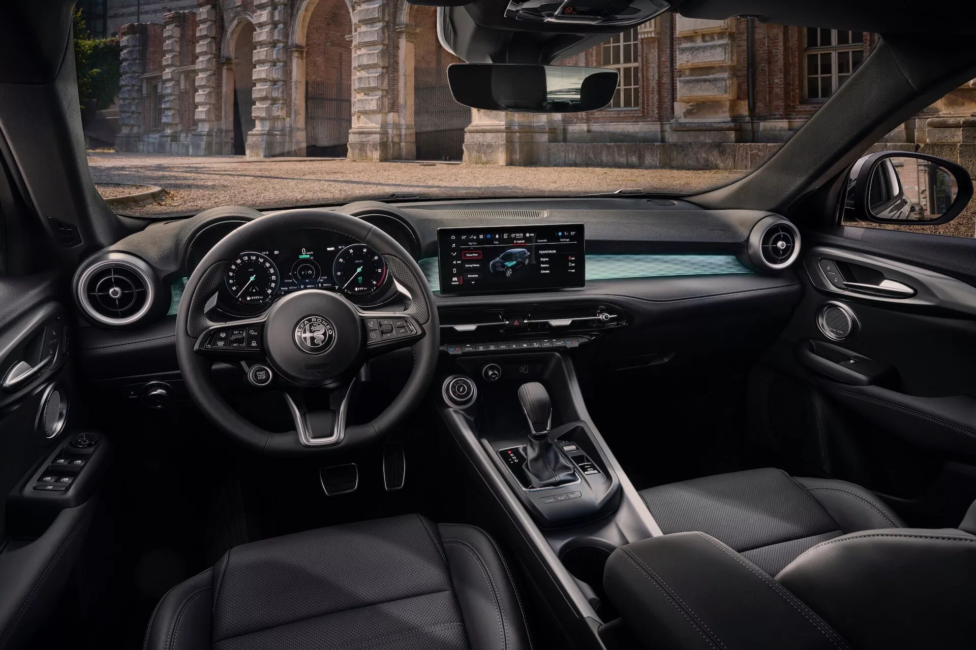 Interiér Alfa Romeo Tonale 2022 z pohľadu zadného cestujúceho s palubnou doskou, volantom s ovládacími tlačidlami, digitálnym prístrojovým panelom, vodorovnou obrazovkou infotainmentu, stredovou konzolou s pákou radenia a luxusnými koženými sedadlami
