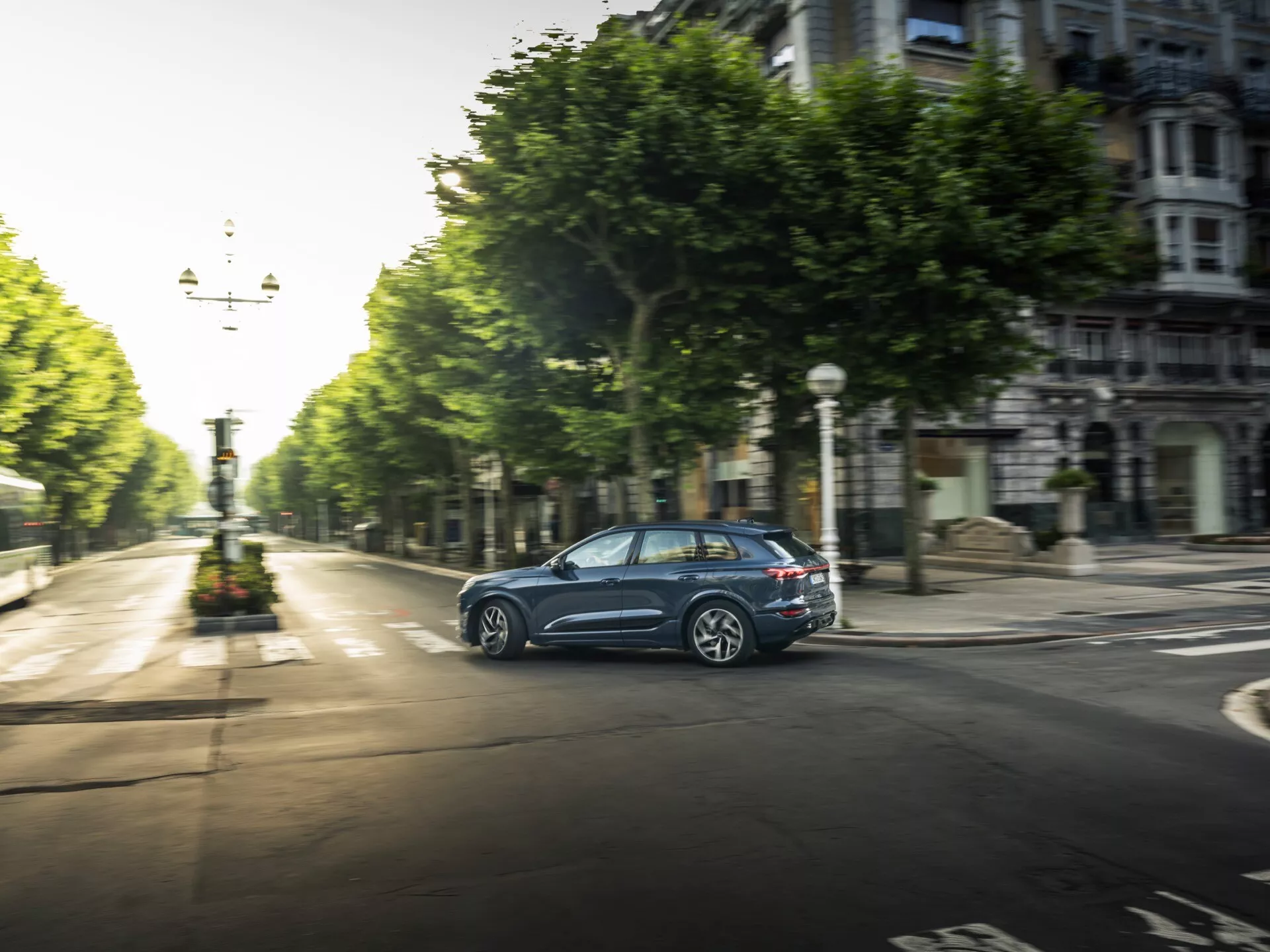 Audi Q6 e-tron 2024 luxusné elektrické SUV, ktoré ponúka elegantný aerodynamický dizajn, špičkovú technológiu, luxusný interiér a pokročilé bezpečnostné prvky, vyfotografované v modernom mestskom prostredí.
