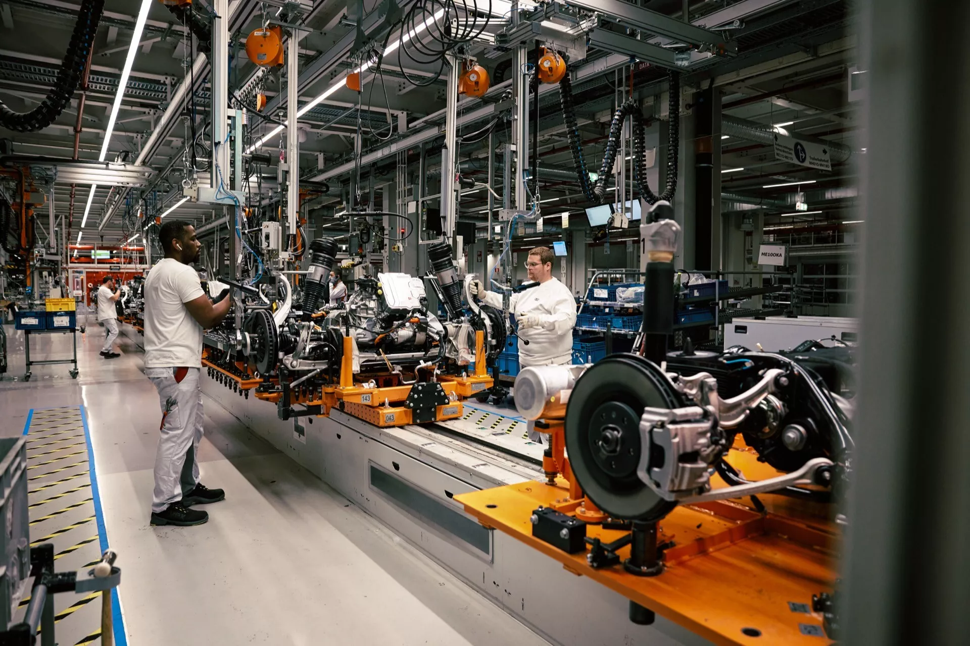 Šasi Audi Q8 e-tron 2023 na montážnej linke vo výrobnej hale, ukazuje konštrukciu vo včasnej fáze, zadný zavesovací systém a technológiu výrobnej linky