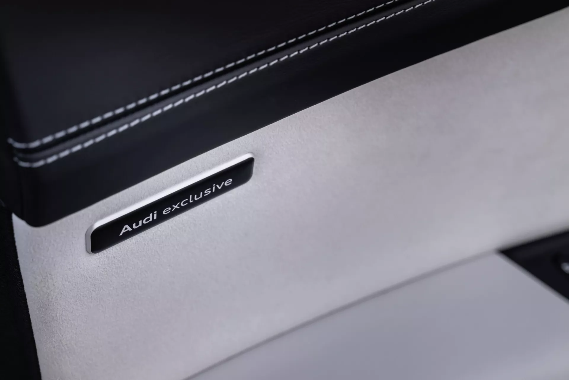 Detailný záber na odznak Audi exclusive na prémiovej koži v interiéri Audi Q8 2023 (4M-Facelift), ktorý predstavuje luxusnú úpravu a kvalitu materiálu