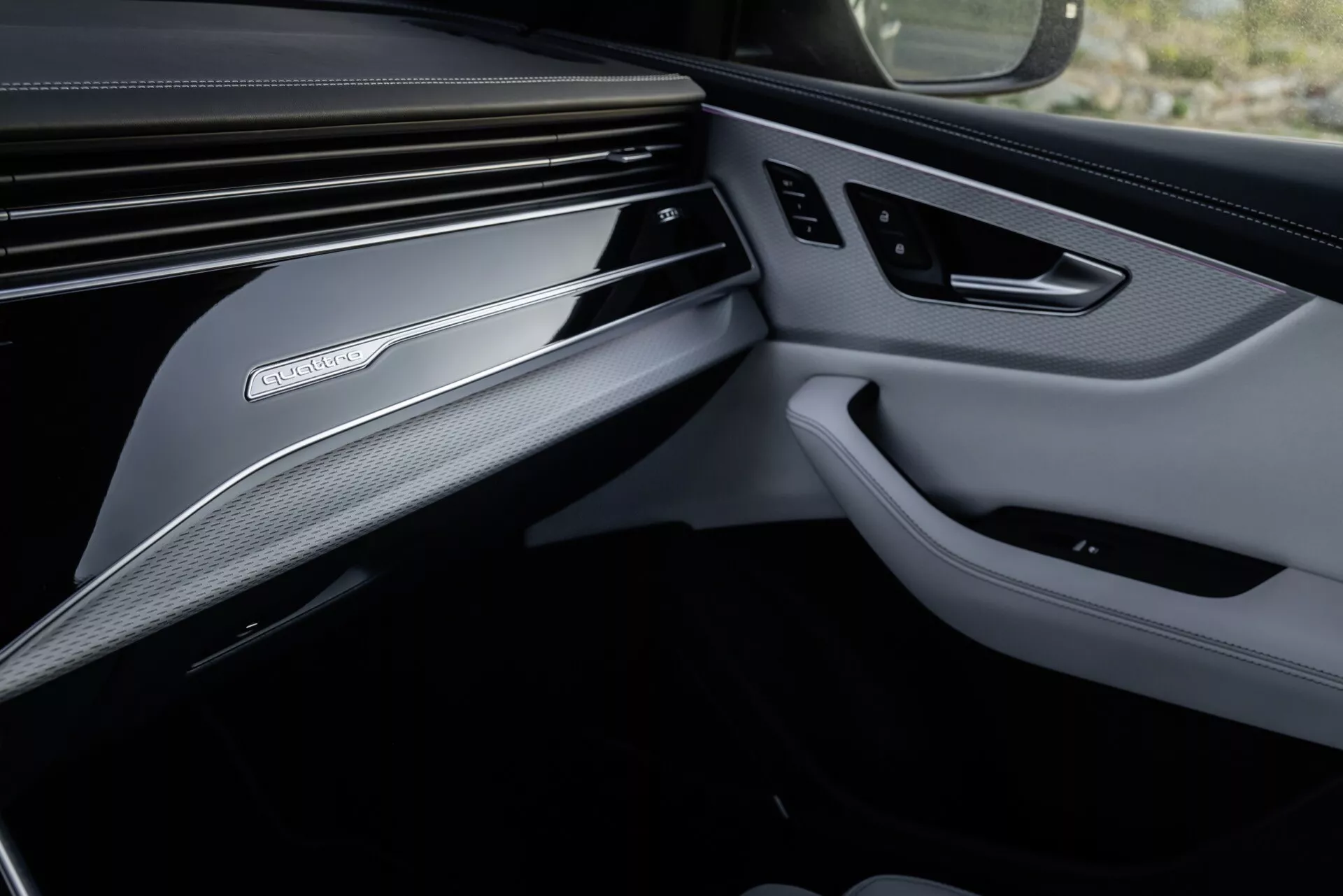 Interiérová fotka Audi Q8 2023 (4M-Facelift) zameraná na luxusný dizajn prednej strany spolujazdca, vrátane detailného pohľadu na palubnú dosku a dverový panel s prémiovými materiálmi a technologickými funkciami