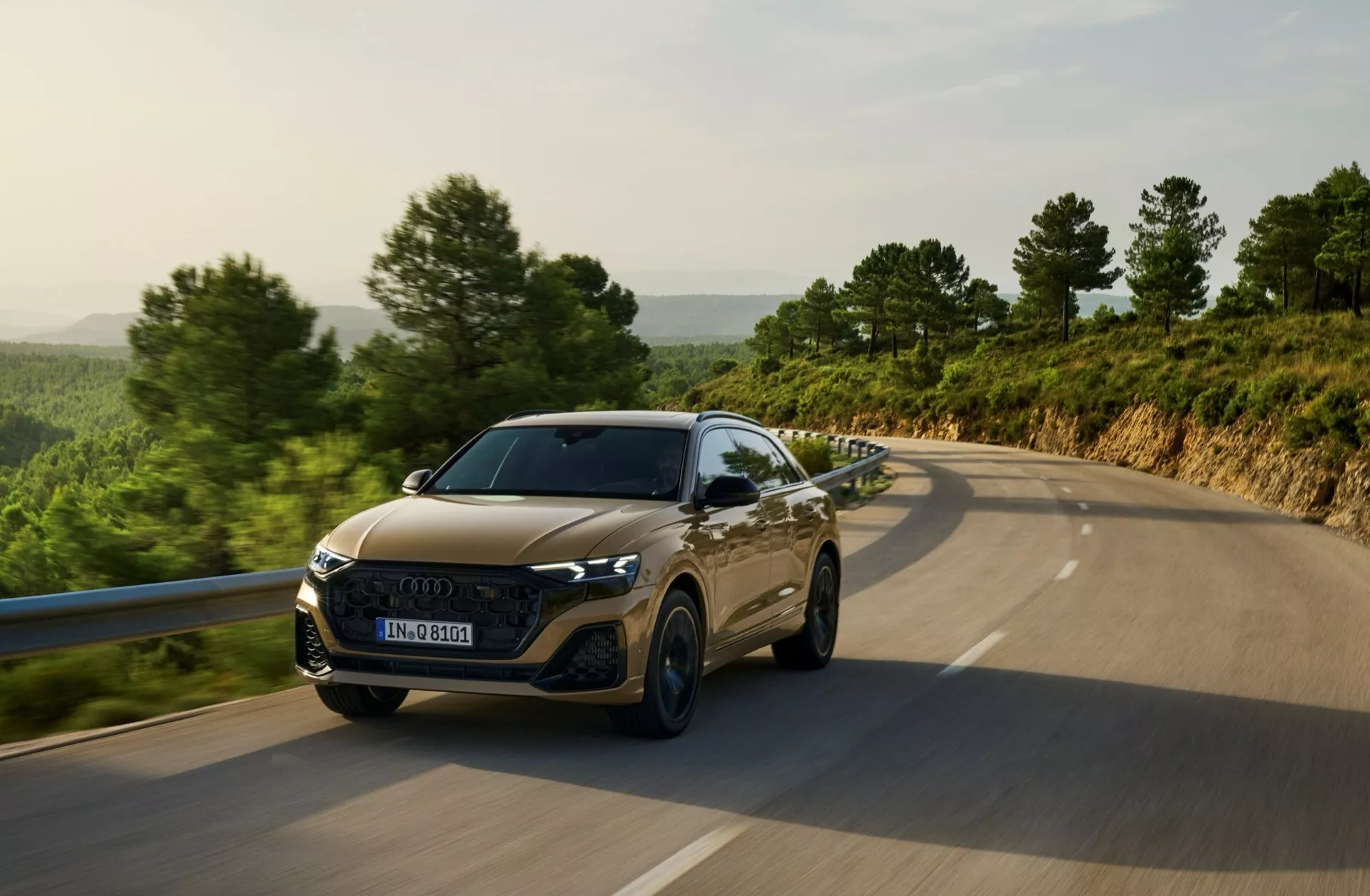 Audi Q8 4M Facelift z roku 2023 cestuje po vidieckej ceste, ukazuje LED svetlomety, šesťuholníkovú mriežku, športové kontúry kapoty a pokročilú technológiu asistencie vodiča