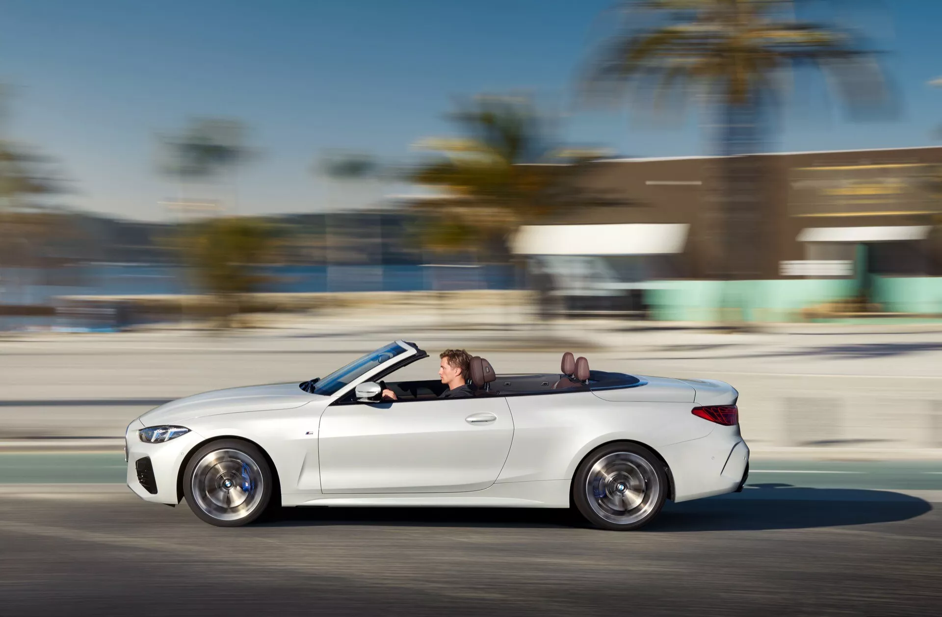 Dynamický bočný profil kabrioletu BMW série 4 z roku 2024 (G22-G23-G26-G82-G83 facelift) v pohybe s viditeľným dizajnom kolies a luxusnými interiérovými detailmi, predvádzajúci rýchlosť a pokročilú technológiu LED svetlometov.