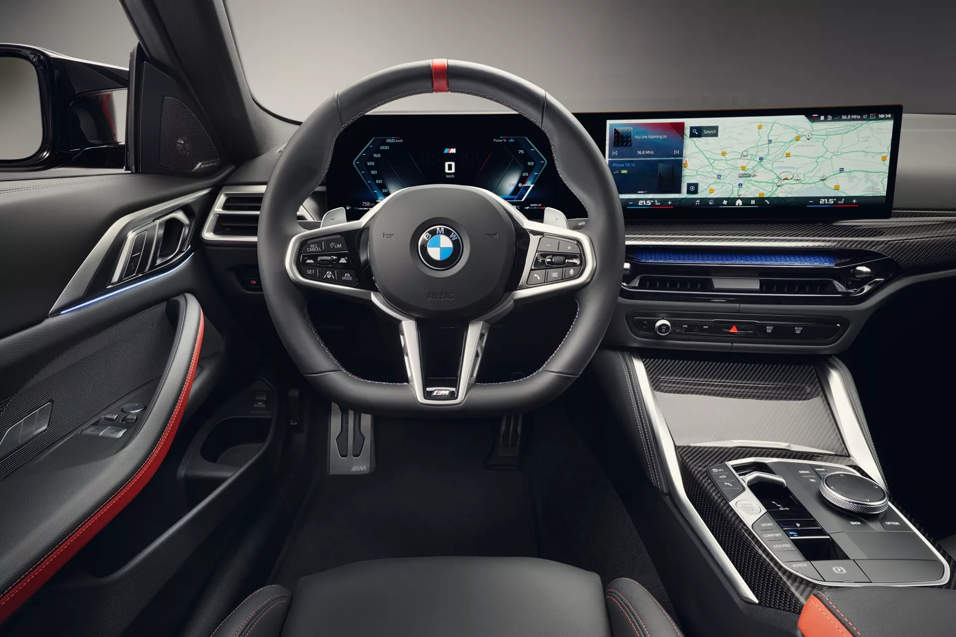 Interiér BMW radu 4 z roku 2024 (G22-G23-G26-G82-G83 Facelift) s dôrazom na športový volant s tromi ramenami a červeným prešívaním, úplne digitálny prístrojový panel a elegantná stredová konzola s veľkým dotykovým displejom. Detaily odhaľujú akcenty z uhlíkových vlákien, luxusné kožené a kovové povrchy a pokročilú technológiu infotainmentu.
