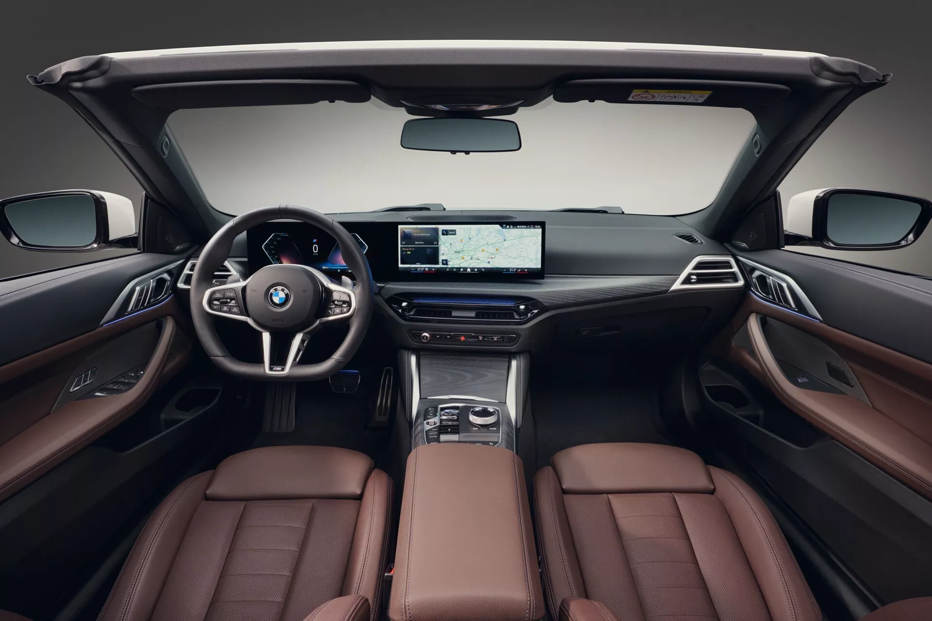 Interiér BMW radu 4 z roku 2024 (G22-G23-G26-G82-G83 Facelift) s luxusnými hnedými koženými sedadlami, modernou palubnou doskou s širokoúhlou obrazovkou a športovým volantom, ktorý zdôrazňuje prvotriedne vlastnosti a dizajn kabíny.