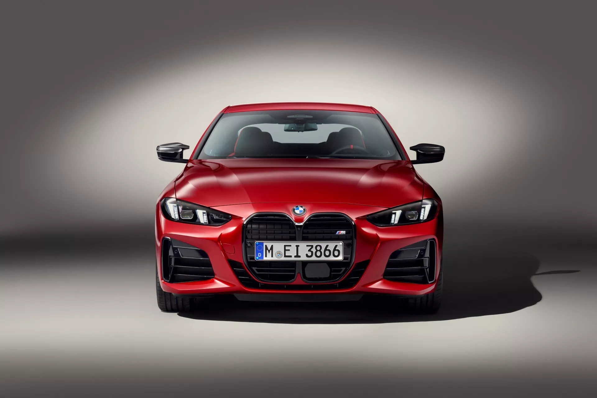 Predný pohľad na BMW radu 4 ročník 2024 (G22-G23-G26-G82-G83 Facelift) s LED svetlomety, veľkou obličkovou mriežkou a aerodynamickým dizajnom na pozadí so šedým prechodom