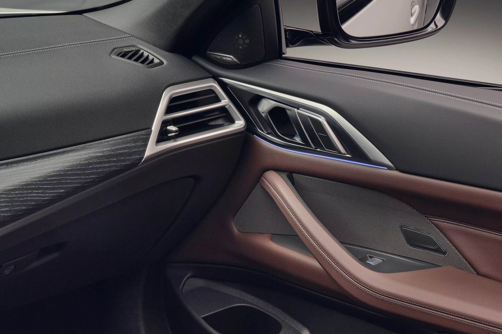 Detailný pohľad na palubnú dosku predného spolujazdca pravostranného riadenia BMW radu 4 2024 (G22-G23-G26-G82-G83-Facelift) s ventiláciami, luxusnými materiálmi a integrovanými ovládačmi.