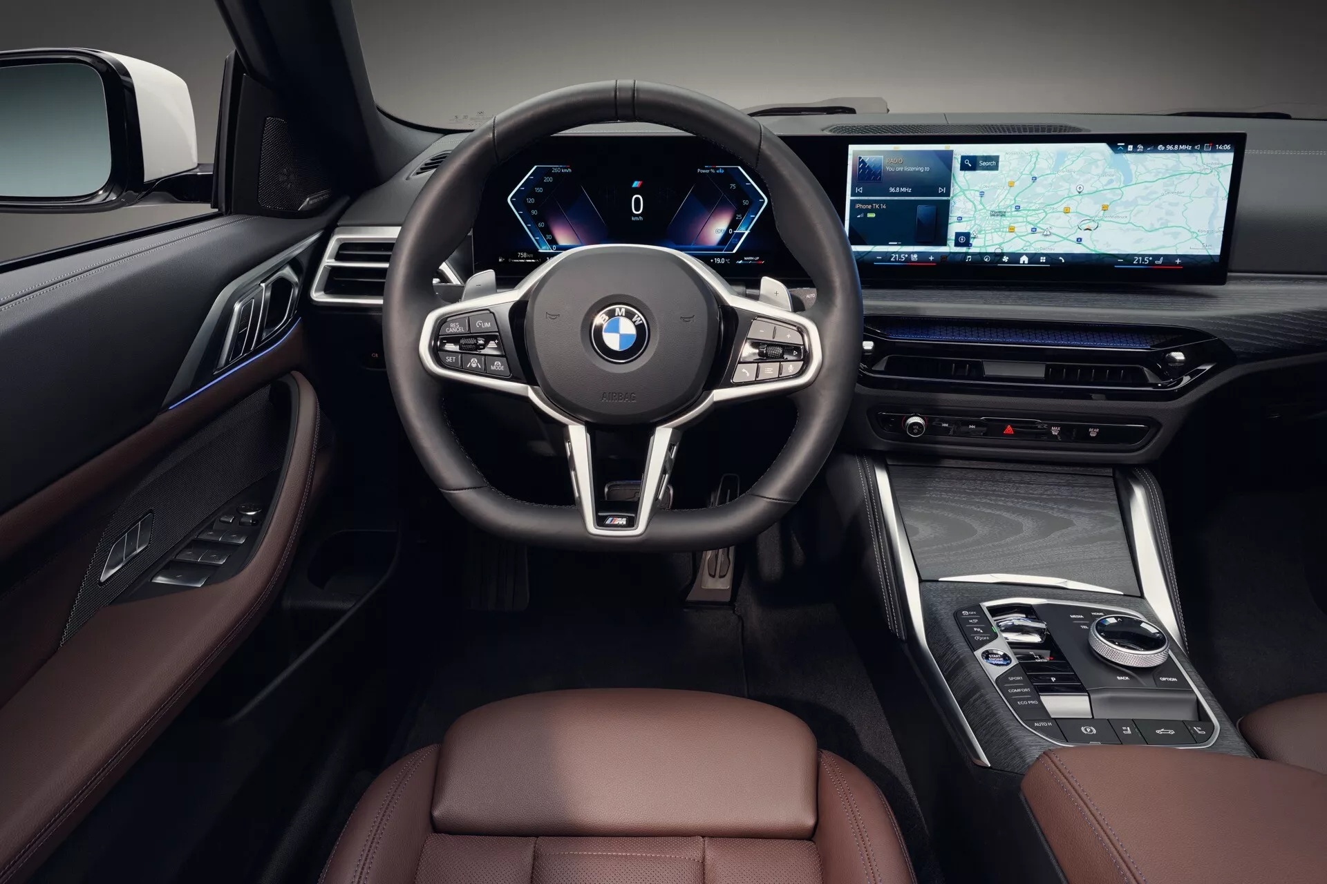 Interiér BMW radu 4 2024 (G22-G23-G26-G82-G83 Facelift), zameraný na oblasť vodiča s digitálnym prístrojovým panelom, multifunkčným volantom, veľkou obrazovkou infotainmentu s navigáciou, luxusnými prevedeniami s kožou a drevotrieskou, z pohľadu prvej osoby