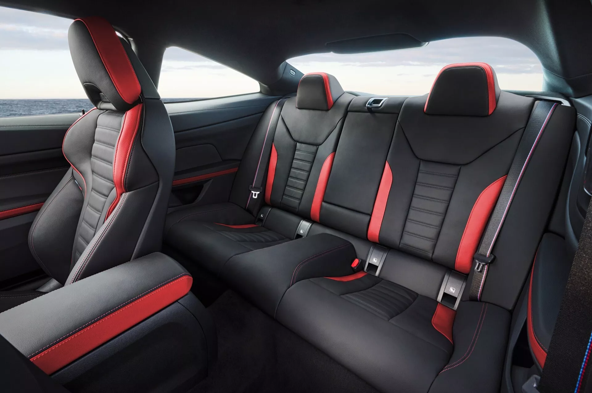 Interiér BMW radu 4 z roku 2024 (G22-G23-G26-G82-G83 FAL) s výhľadom na zadné sedadlá so športovým dizajnom, čiernymi a červenými koženými a Alcantara sedadlami a pokročilými bezpečnostnými prvkami