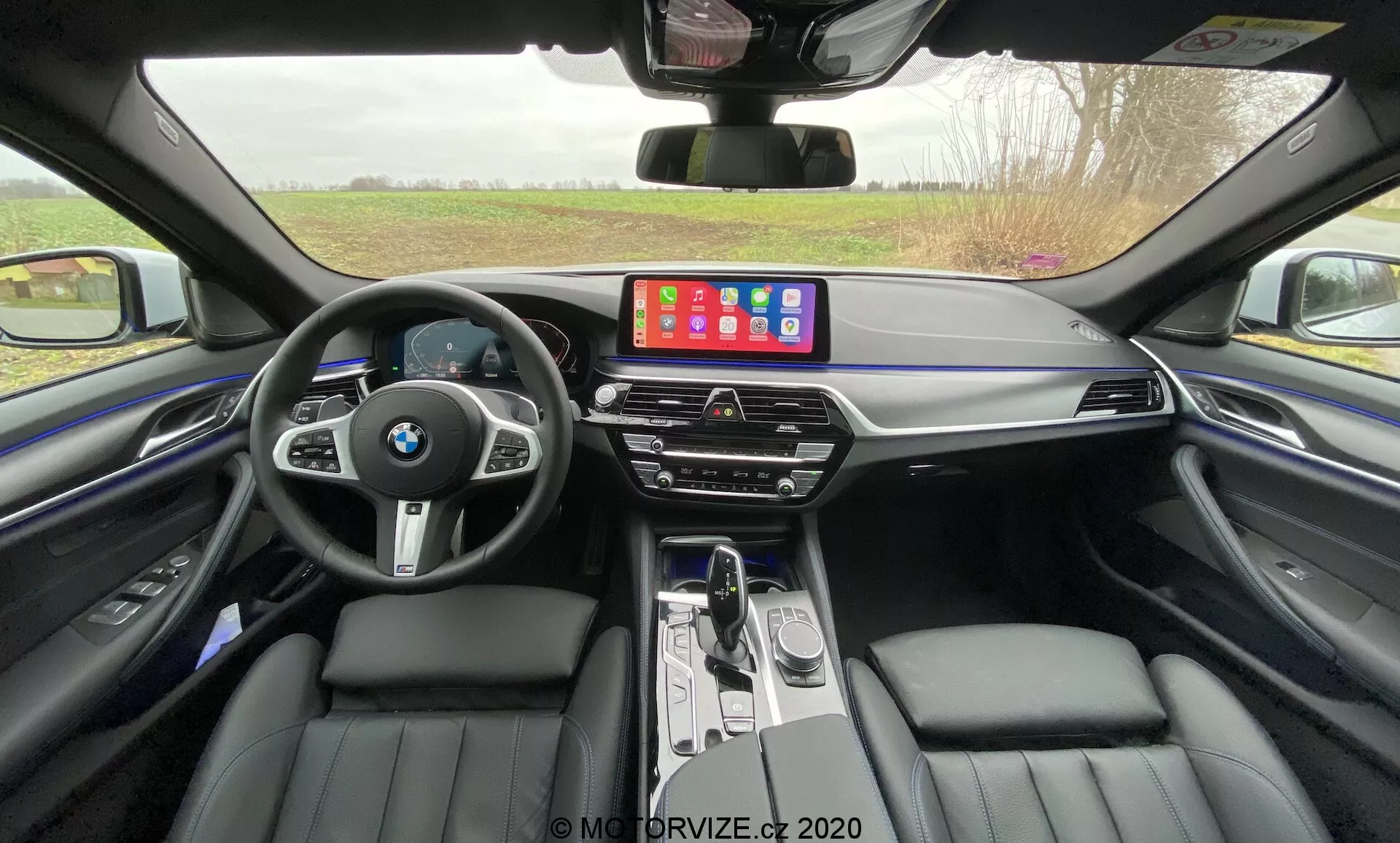 Predný pohľad na BMW 520i Touring Steptronic z roku 2020 v elegantnom kovovom povrchu, ktorý ukazuje jeho elegantný dizajn, pokročilé LED svetlomety a ikonickú obličkovú masku v modernom mestskom prostredí.