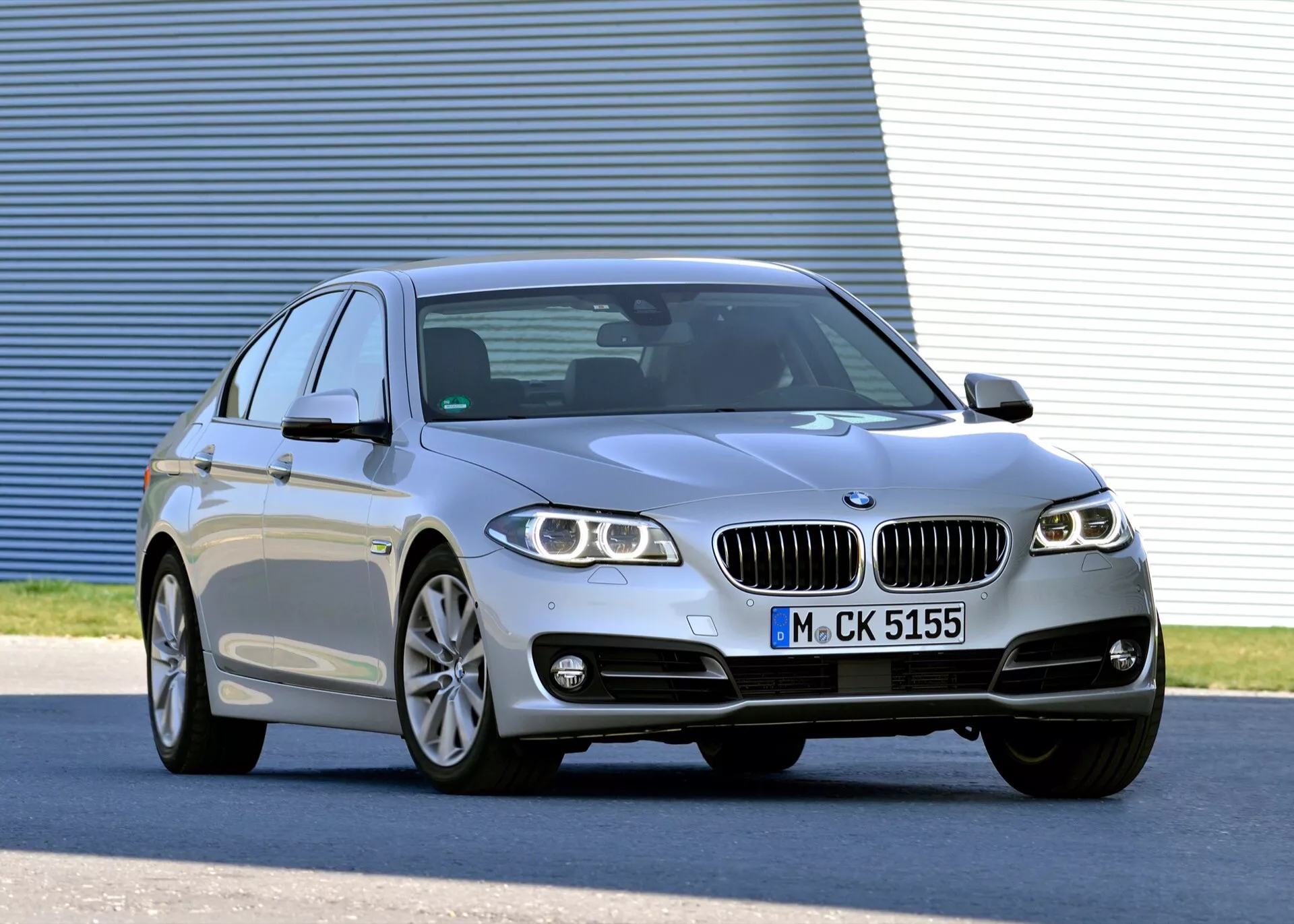 Strieborný luxusný sedan BMW radu 5 (F07-F10-F10M-F11-Facelift) z roku 2013 v trojštvrťovom prednom uhle zobrazujúci LED svetlomety, zliatinové kolesá, dvojitú obličkovitú mriežku, športovú štvordverovú karosériu so strechou ako kupé a pokročilé technologické funkcie