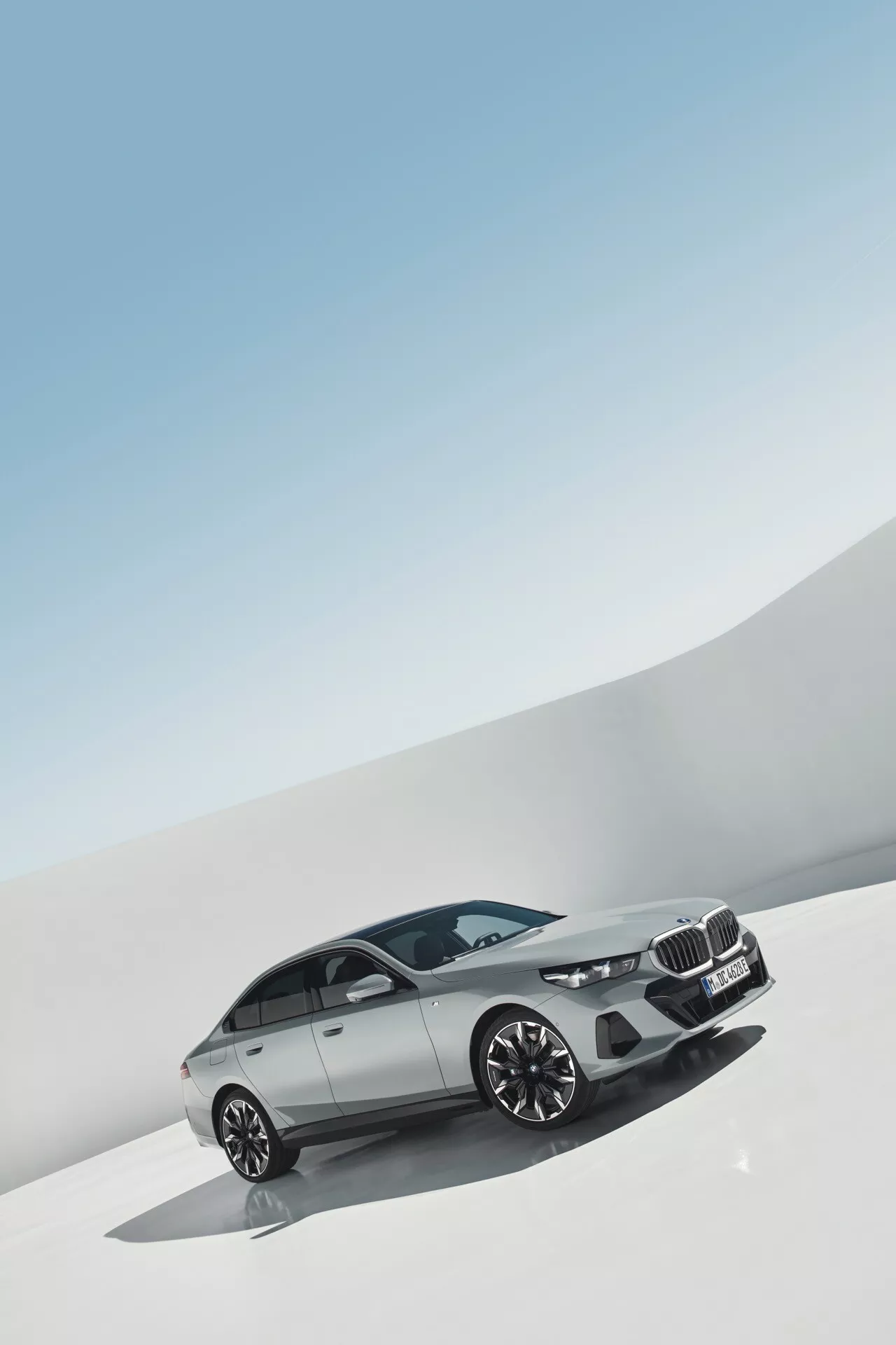Luxusný sedan BMW radu 5 (G60-G61) ročník 2023 zobrazený pod miernym uhlom, zdôrazňujúci jeho elegantný dizajn, obličkovitú mriežku, moderné LED svetlomety, profilovaný predný nárazník so vzduchovými otvormi a zliatinové kolesá s viacpriehradkovým dizajnom a metalickou úpravou