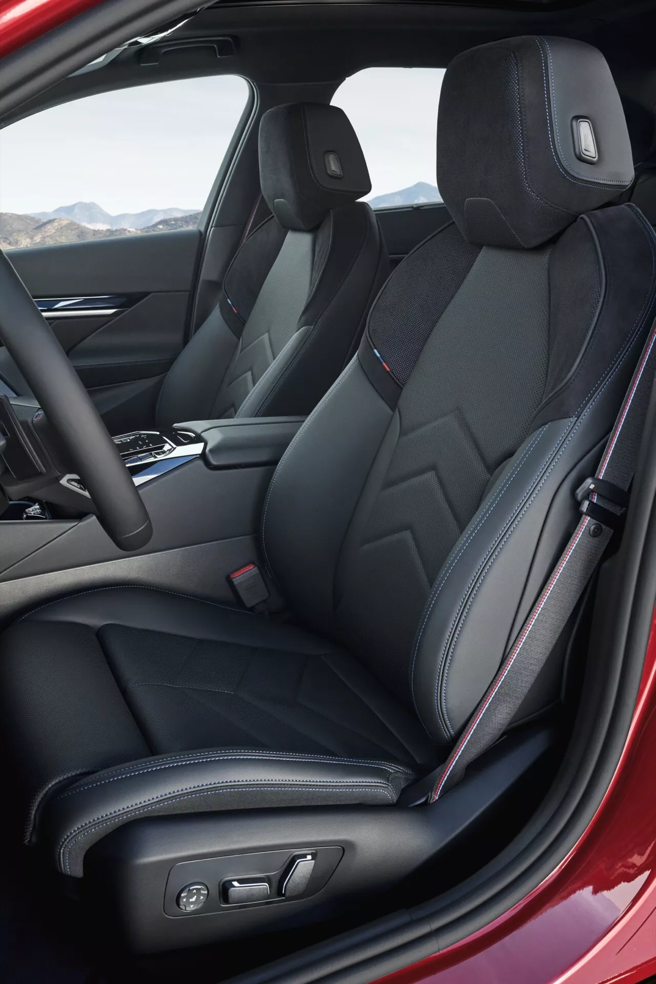 Interiérový pohľad na BMW radu 5 2023 (G60-G61) so zameraním na športové predné sedadlá s čiernym koženým čalúnením a charakteristickým prešívaním, elektronické nastavenie sedadiel a modernú stredovú konzolu, zachytené z uhlového pohľadu vodičovej strany.