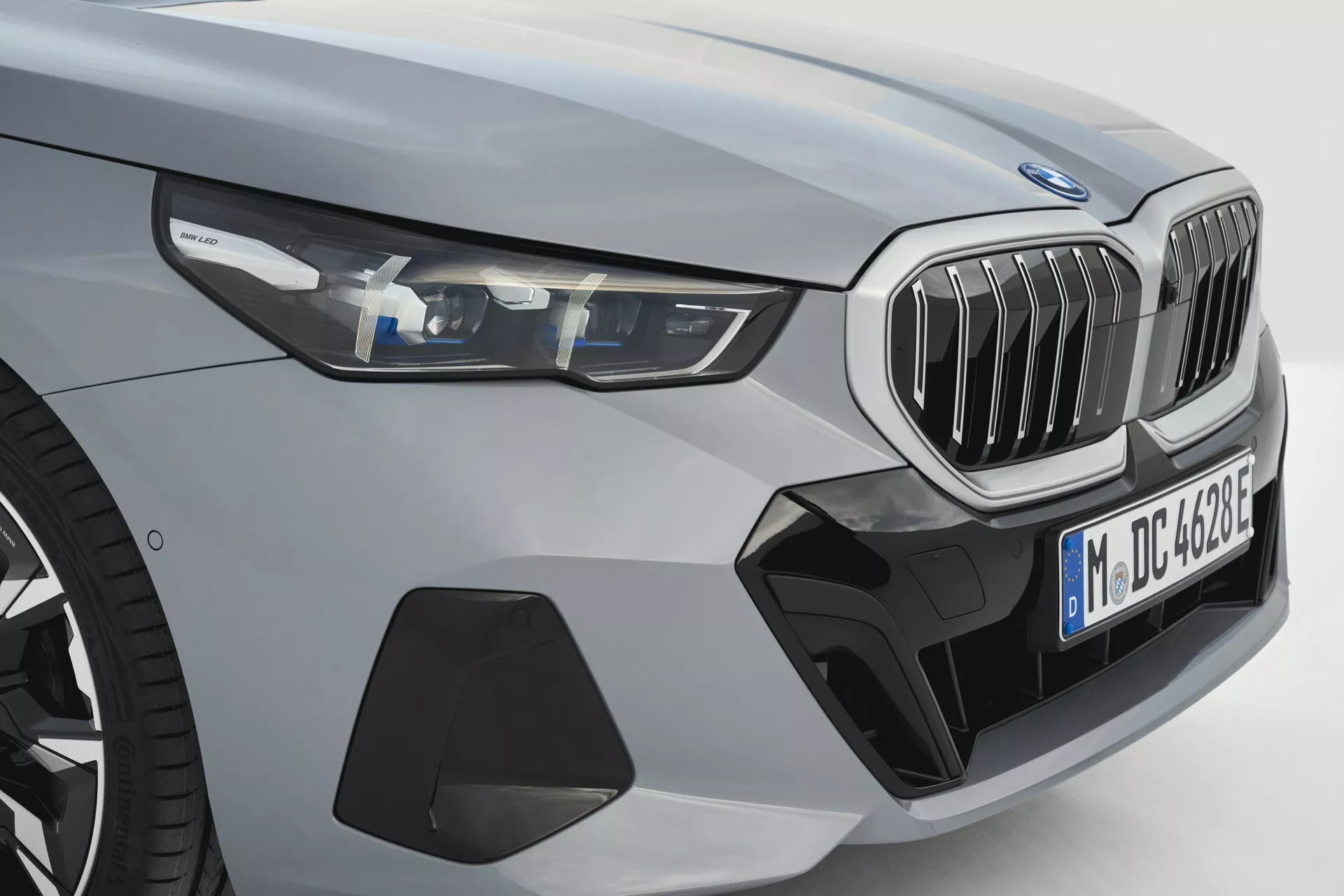 Pohľad z prednej ľavej štvrtiny na BMW radu 5 (G60-G61) rok 2023 ukazujúci LED svetlomety, charakteristickú obličkovitú mriežku, športový predný nárazník s otvormi pre prívod vzduchu, profilovanú kapotu, široké blatníky a metalízový povrch