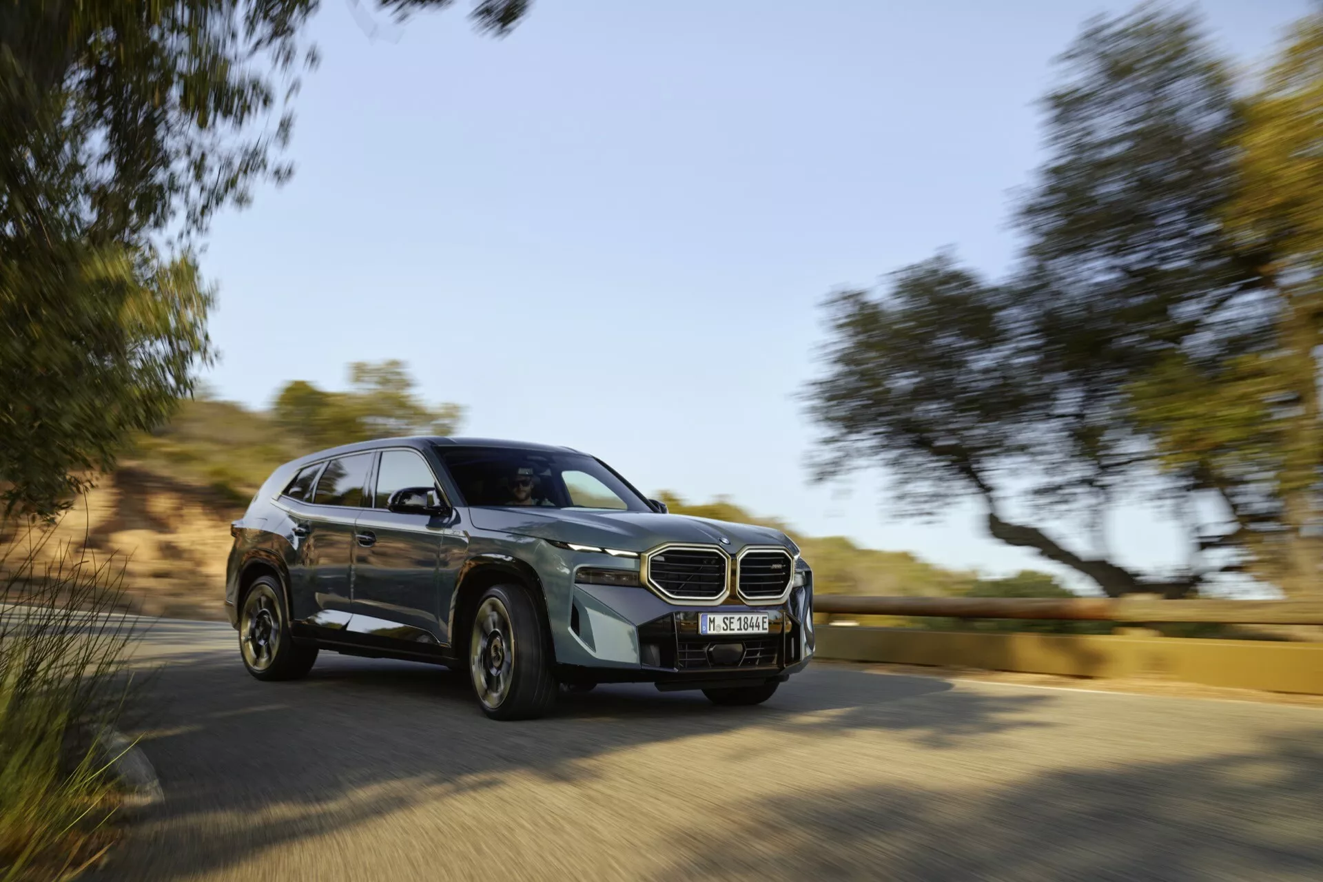 BMW XM (G09) 2023 v pohybe, ukazuje na moderný dizajn SUV z dynamického predného uhla, zdôrazňuje pokročilé funkcie ako ikonická mriežka a LED svetlomety