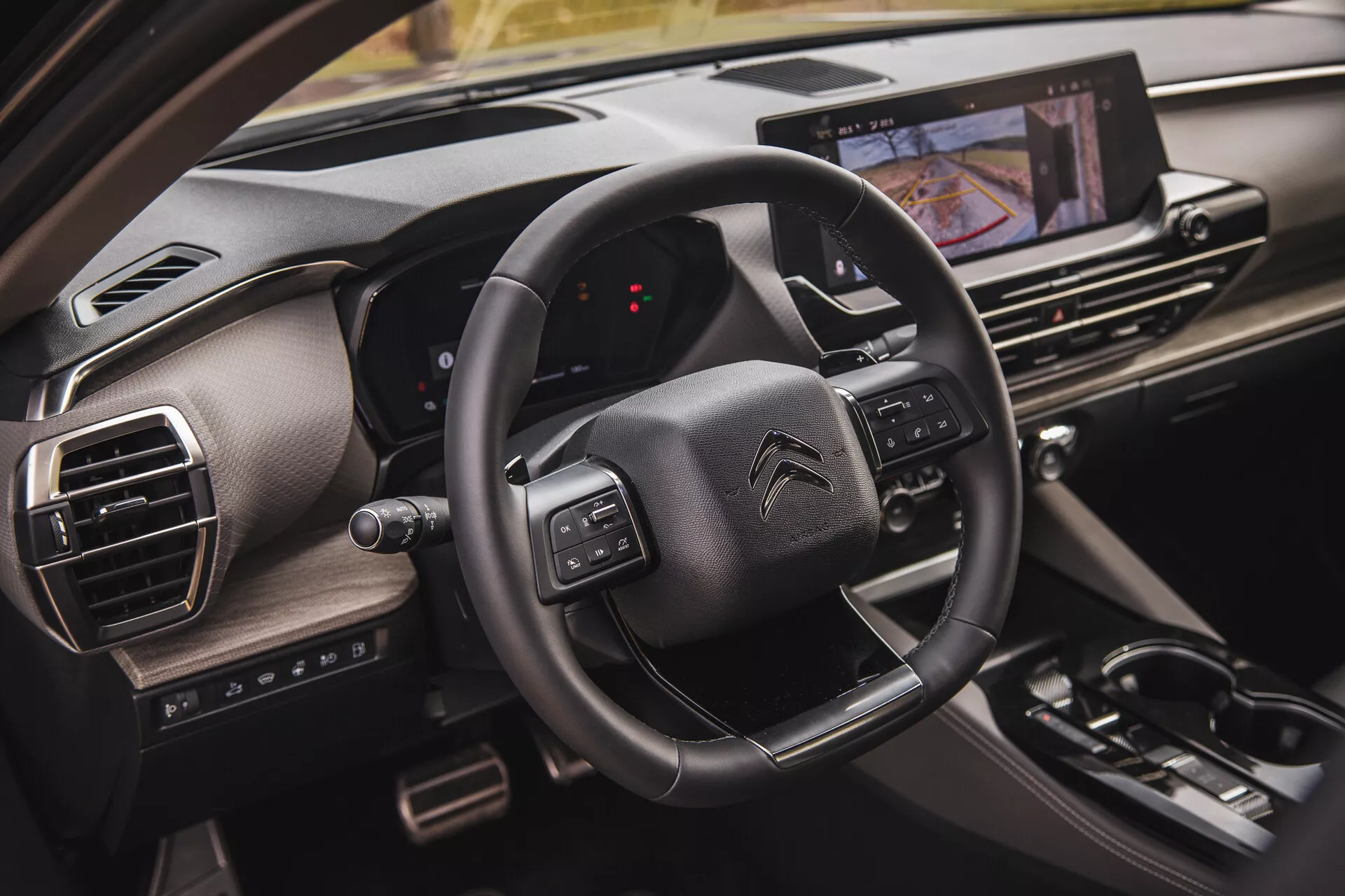 Detailný pohľad na interiér Citroën C5-X 2022, ktorý ukazuje volant s multifunkčnými tlačidlami, digitálny displej prístrojovej dosky z perspektívy spolujazdca a dotykový informačno-zábavný systém