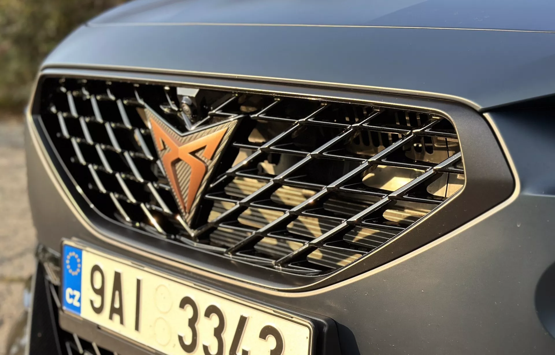 Detailný pohľad na prednú mriežku a nárazník Cupra Formentor 2020 zobrazujúci emblém, horizontálne lišty a kovový finiš, zvýrazňujúci jeho automobilový dizajn a značku