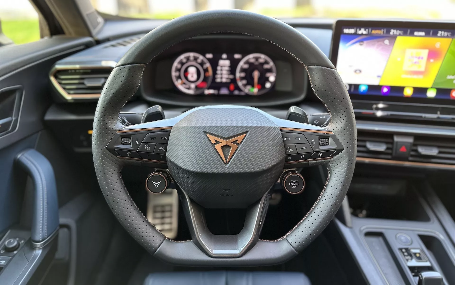 Interiérový pohľad na Cupra Formentor 2020 z pohľadu vodiča, zdôrazňujúci kožený volant s tromi ramenami s multifunkčnými tlačidlami, digitálny prístrojový panel a dotykový informačno-zábavný systém.