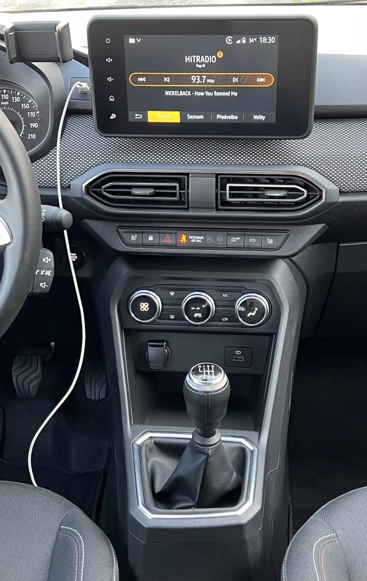 Interiér Dacia Jogger 2022 so zameraním na stredovú konzolu a prístrojovú dosku, s plávajúcou dotykovou obrazovkou infotainmentu, vzduchovými vývodmi, ovládaním klímy a vozidla a manuálnou prevodovkou