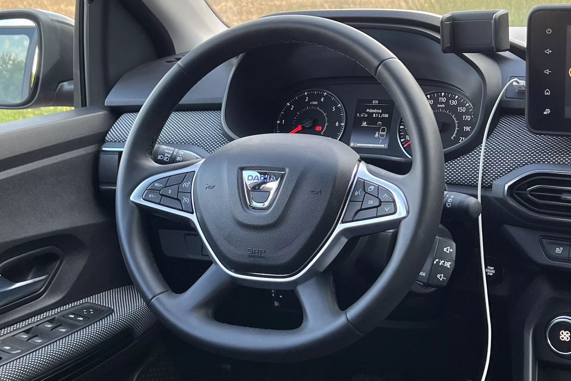 Interiér Dacie Jogger 2022 z pohľadu vodiča, zameraný na volant s multifunkčnými ovládačmi a palubnú dosku s infotainment systémom