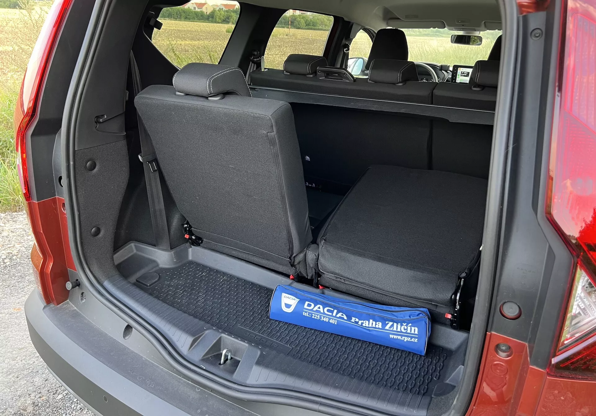 Dacia Jogger 2022 zobrazujúca vnútorný nákladný priestor z uhla ľavej strany s otvoreným batožinovým priestorom, predstavujúca plochú nákladnú plochu s gumovou podložkou, zadné sedadlá sklopné v pomere 60/40 a detaily bočného obloženia bez viditeľných pokročilých technológií alebo luxusných komponentov