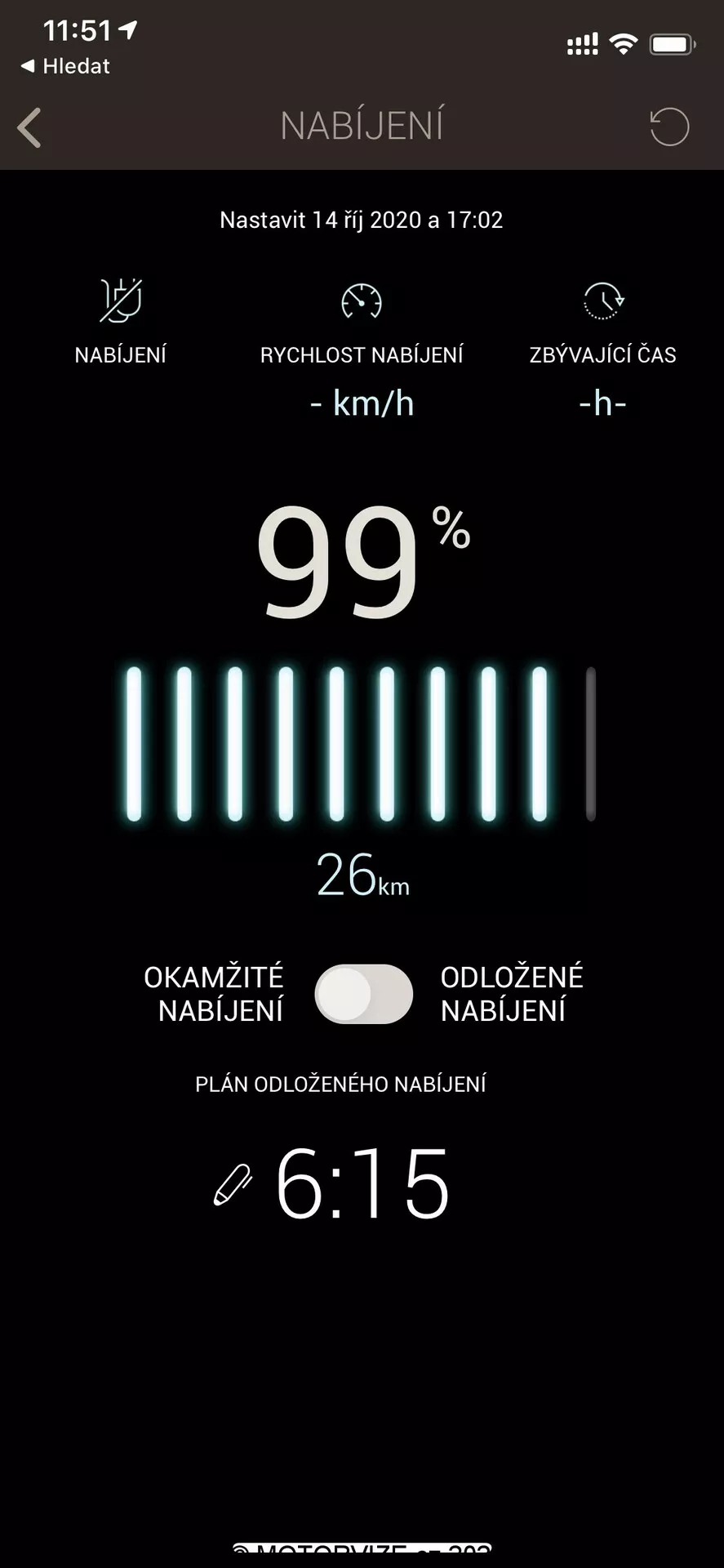 Snímka obrazovky zobrazujúca stav nabíjania elektromobilu v mobilnej aplikácii alebo v rozhraní infotainment systému. Hore sa zobrazuje ikona batérie a slovo 'NABIJENI,' čo znamená nabíjanie po česky. Nižšie vidieť nastavenie na 14. októbra 2020 o 17:02. Stavový pruh batérie je takmer úplne nabitý na 99 % s ukazovateľom dojazdu 26 km. Dve tlačidlá označené 'Okamžité nabíjanie' a 'Odložené nabíjanie' umožňujú kontrolu času nabíjania. Na spodku sa zobrazuje hodiny ukazujúce 6:15 pre odložené nabíjanie. Rozhranie má čistý dizajn s čiernym pozadím a bielym a zeleným textom, ideálnym na zlepšenie čitateľnosti.