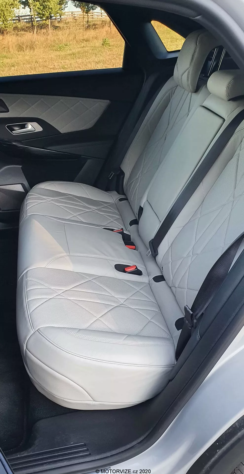 Detailný záber zadného sedadla DS Automobiles DS-7 2018 ukazujúci bielu kožu s diamantovým prešívaním, opierkou hlavy, trojbodovým bezpečnostným pásom a systémom LATCH, zdôrazňujúci luxusný dizajn interiéru a bezpečnostné prvky vozidla