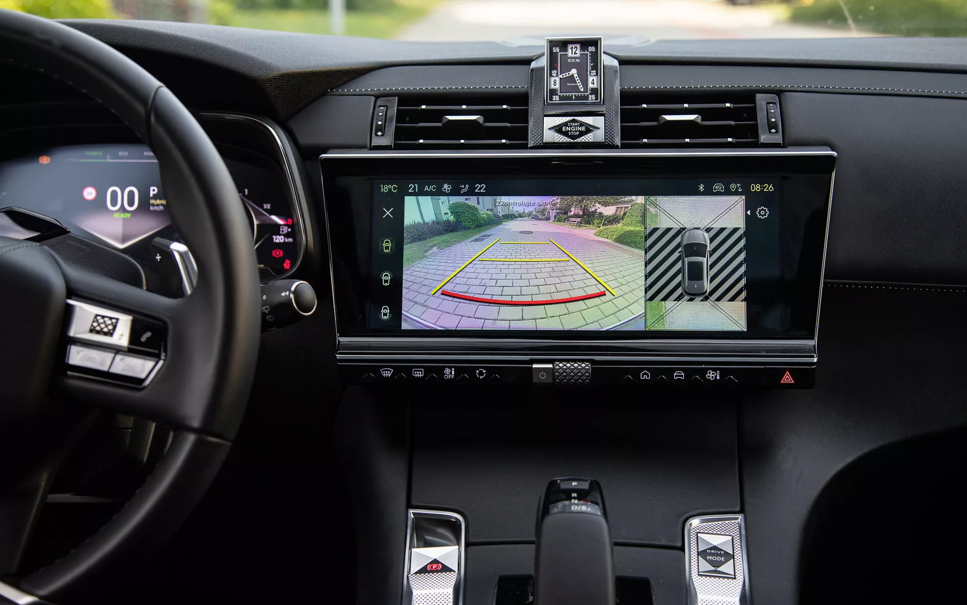 Detail luxusného interiéru DS-7 2022 s infotainment systémom zobrazujúcim displej kamery vzadu a dynamickými pokynmi pre parkovaciu asistenciu, centrálnymi ventiláciou, tlačidlami na ovládanie klímy, športovou radiacou pákou a digitálnym rýchlosťomerom