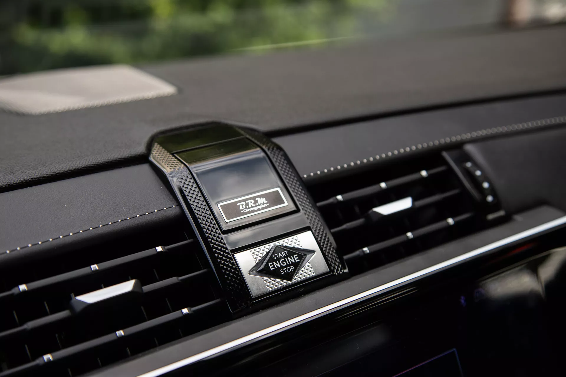 Detailný pohľad na stredovú palubnú dosku DS Automobiles DS-7 2022 s luxusným analógovým hodinami a ventiláciami vzduchu, zdôrazňujúci prémiové materiály a moderný dizajn