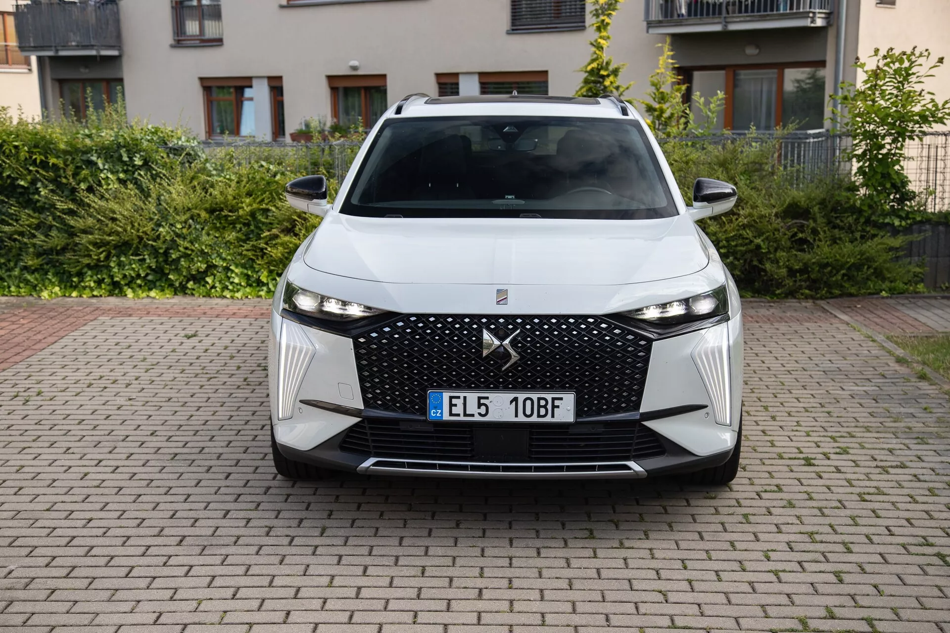 Pohľad z predu na DS Automobiles DS-7 2022 ukazuje jeho moderný dizajn, vrátane veľkej mriežky s diamantovým vzorom, úzkych LED svetlometov, uhlových vzduchových vstupov a pokročilých asistenčných systémov vodiča