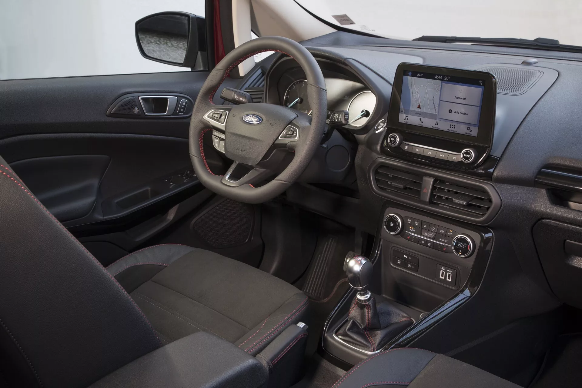 Interiér Ford EcoSport 2017 (1. generácia - Facelift) zameraný na stranu vodiča s multifunkčným volantom, displejom palubnej dosky, manuálnou prevodovkou a systémom klimatizácie